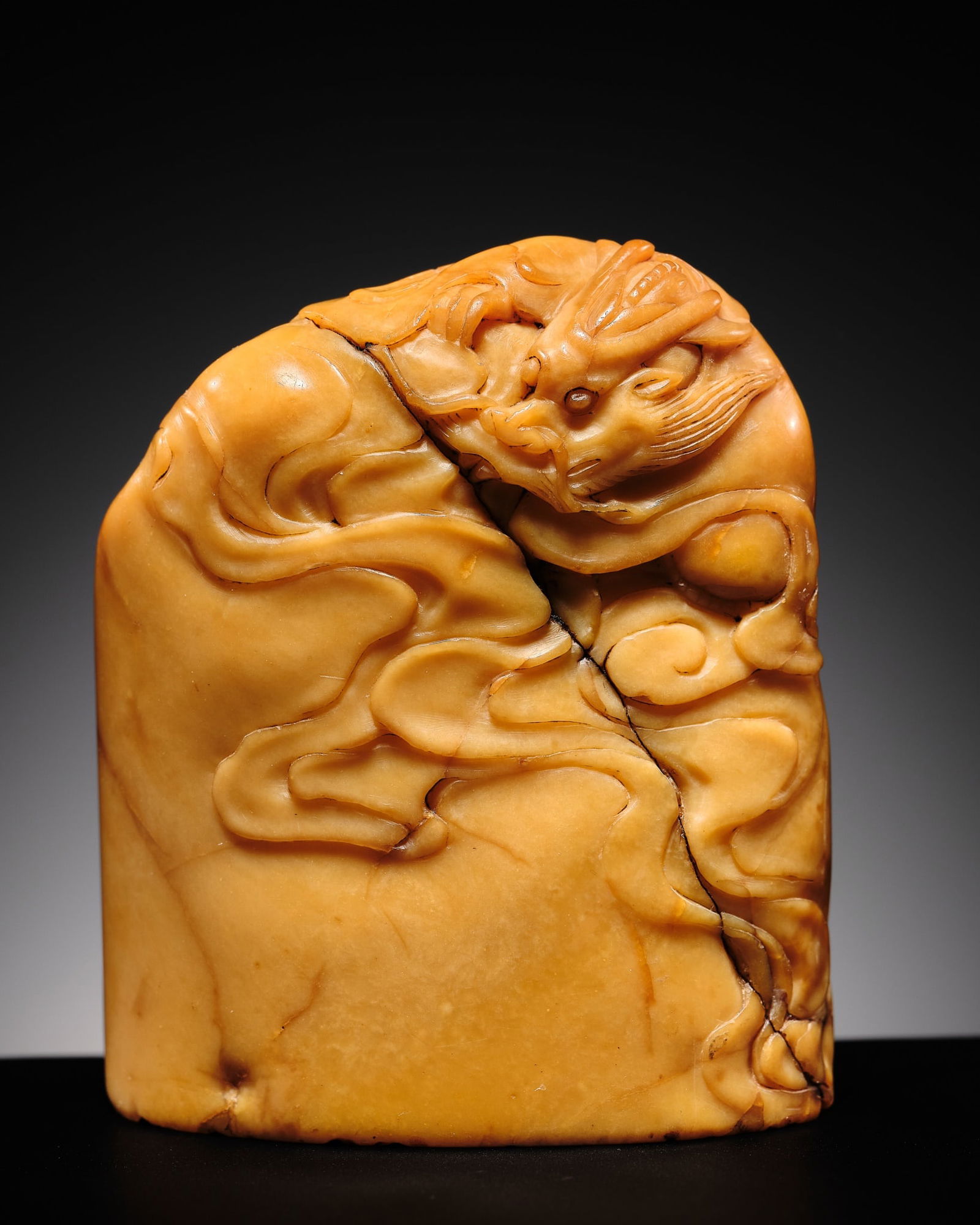 A VERY RARE AND LARGE TIANHUANG SOAPSTONE 'DRAGON' SEAL, QING DYNASTY: A VERY RARE AND LARGE TIANHUANG SOAPSTONE 'DRAGON' SEAL, QING DYNASTY China, 18th-19th century. Oblong in form with an oval cross-section, finely carved in varying degrees of relief to depict a drago