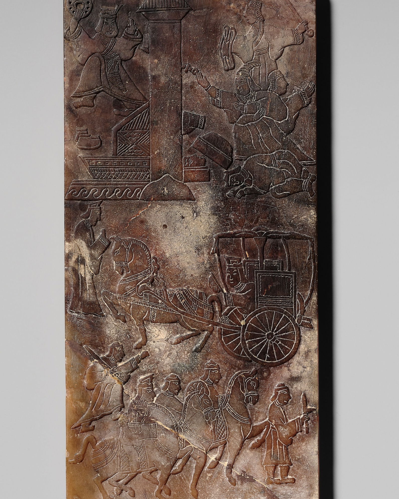 A SOAPSTONE COVER OF A BOX, EASTERN HAN DYNASTY TO SIX DYNASTIES: A SOAPSTONE COVER OF A BOX, EASTERN HAN DYNASTY TO SIX DYNASTIES China, 8-589 AD. The rectangular cover carved in low relief do depict several figural scenes with warriors on horseback, a carriage dr
