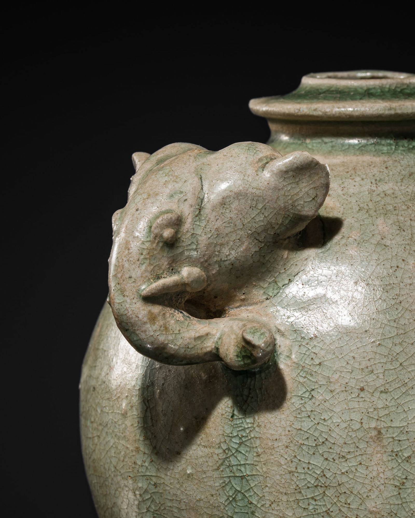 A SAWANKHALOK GREEN-GLAZED STONEWARE 'ELEPHANT' JAR: A SAWANKHALOK GREEN-GLAZED STONEWARE 'ELEPHANT' JAR Thailand, Sukhothai province, 15th-16th century. Of globular form, gently tapering toward a flat base and rising to a short, flanged neck with a na