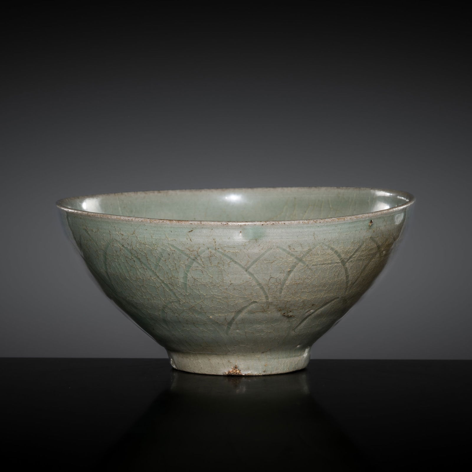 A CELADON-GLAZED STONEWARE 'LOTUS PETAL' BOWL, GORYEO PERIOD: A CELADON-GLAZED STONEWARE 'LOTUS PETAL' BOWL, GORYEO PERIOD Korea, 12th century. Well potted with deep, rounded sides rising from a short, slightly tapered foot. The exterior decorated with a three-