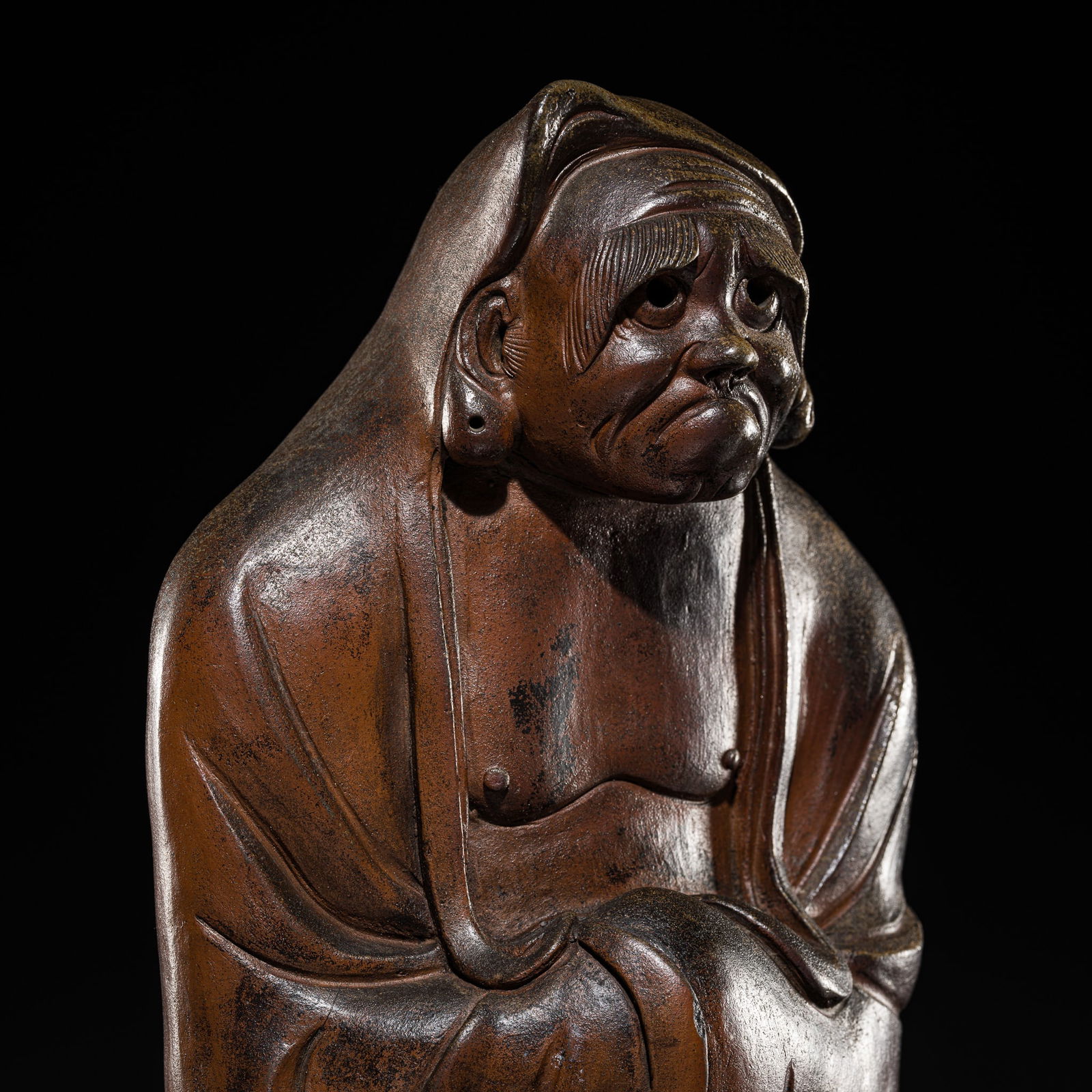 A MASSIVE BROWN-GLAZED STONEWARE FIGURE OF DARUMA, EDO PERIOD: A MASSIVE BROWN-GLAZED STONEWARE FIGURE OF DARUMA, EDO PERIOD Japan, Bizen kilns, 18th to mid-19th century. Heavily potted, standing with a slight forward bend, with hands clasped