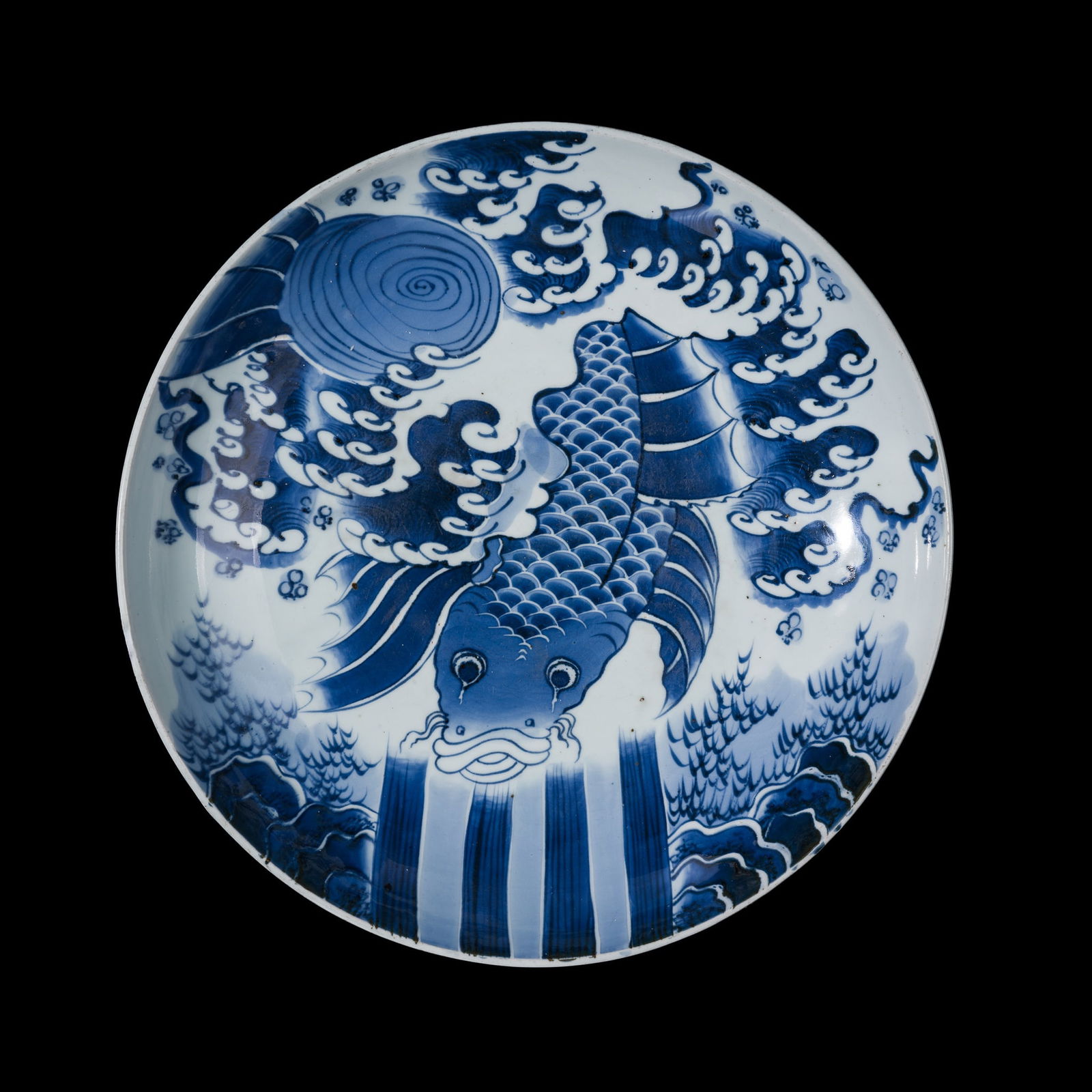A VERY LARGE (46 CM) BLUE AND WHITE PORCELAIN DISH WITH A CARP ASCENDING WATERFALLS, EDO PERIOD: A VERY LARGE (46 CM) BLUE AND WHITE PORCELAIN DISH WITH A CARP ASCENDING WATERFALLS, EDO PERIOD Japan, 19th century. Well-potted, with deep, rounded sides resting on a short, slightly tapered foot wi