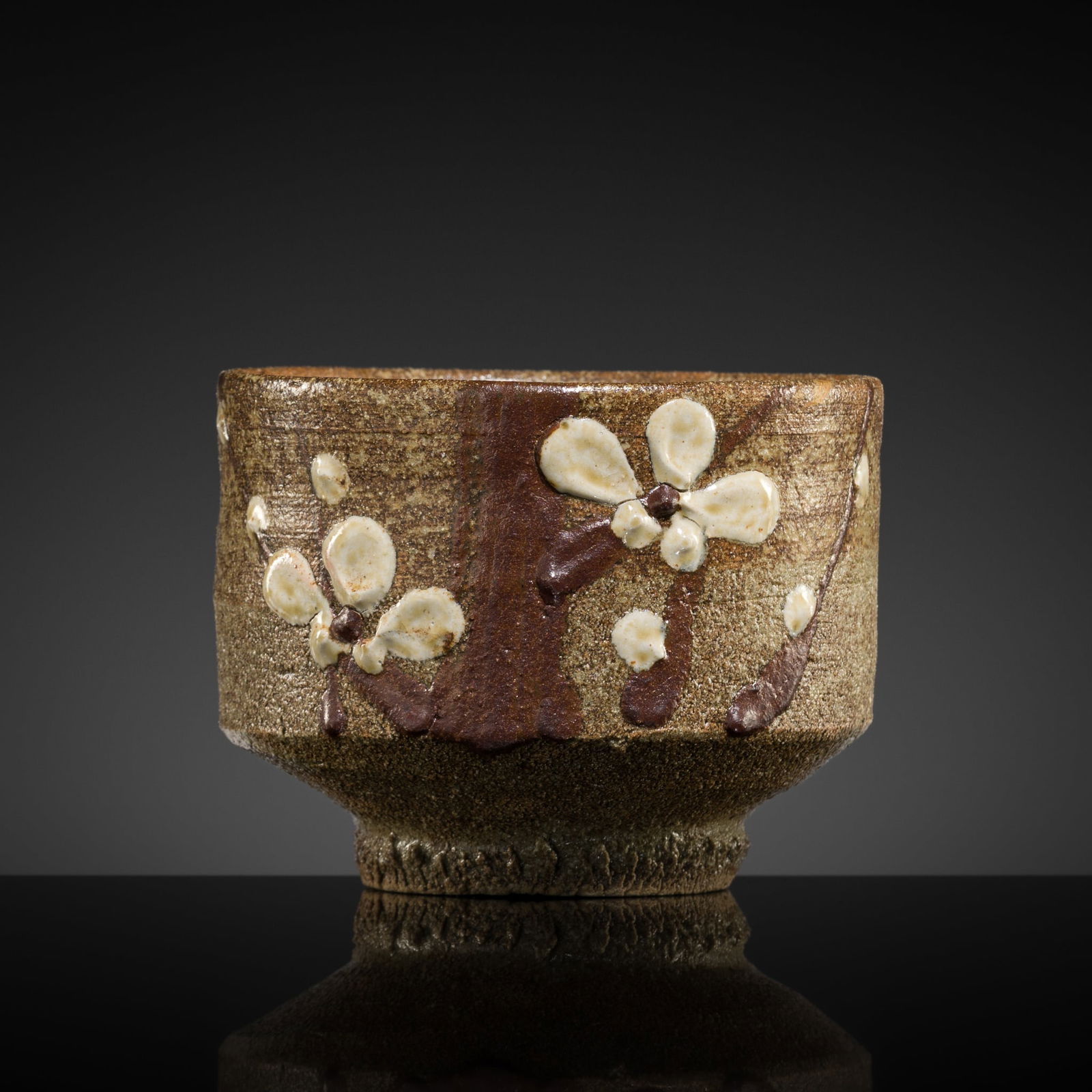 A FINE WHITE- AND BROWN-GLAZED STONEWARE 'PRUNUS' TEA BOWL (CHAWAN): A FINE WHITE- AND BROWN-GLAZED STONEWARE 'PRUNUS' TEA BOWL (CHAWAN) Japan, 19th-20th century. Well-potted, with tall, straight sides rising from a knife-cut foot, entirely glazed in varying s