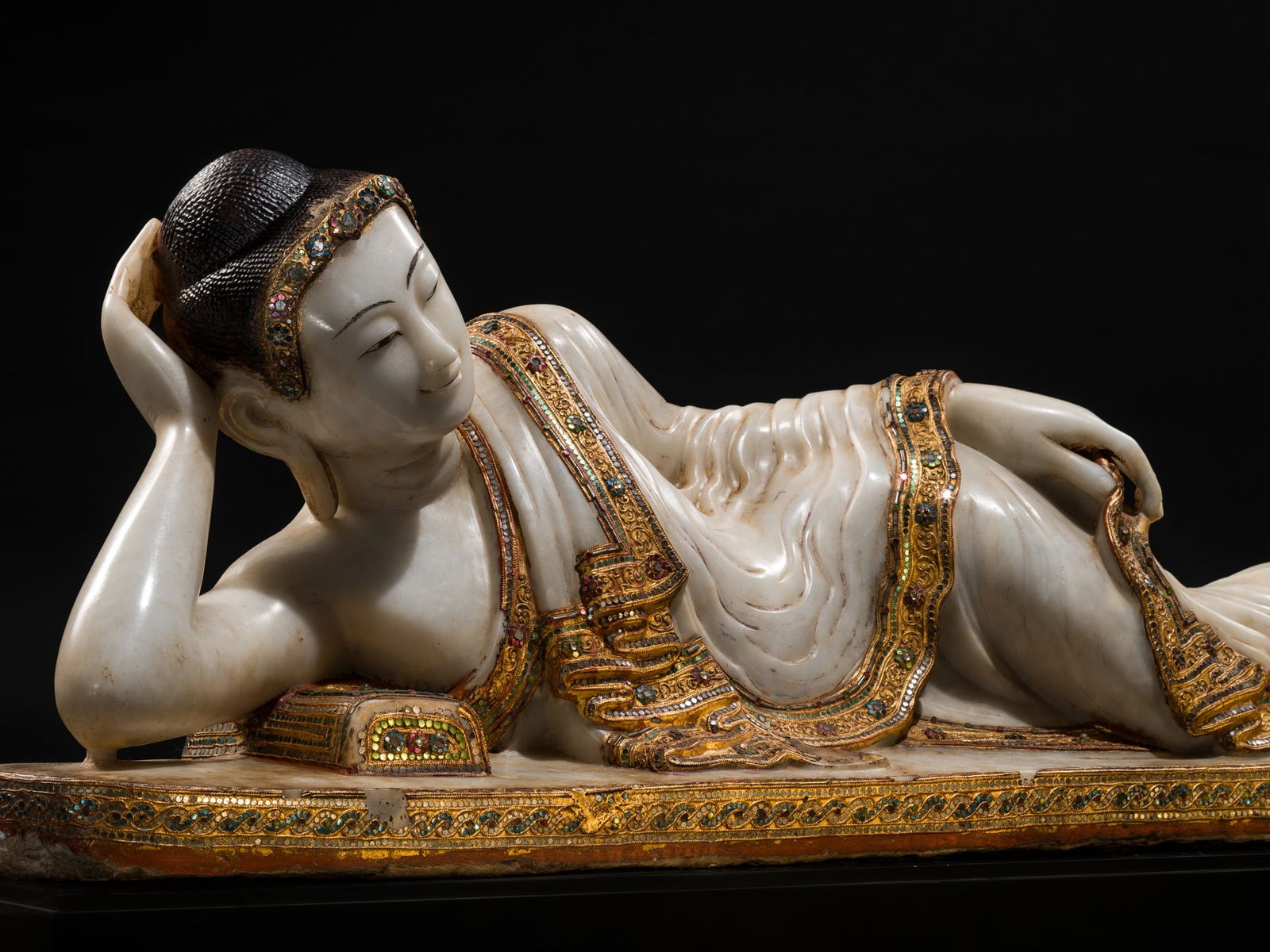 A LARGE GLASS INLAID AND GILDED ALABASTER FIGURE OF THE RECLINING BUDDHA, MANDALAY PERIOD, 19TH: A LARGE GLASS INLAID AND GILDED ALABASTER FIGURE OF THE RECLINING BUDDHA, MANDALAY PERIOD, 19TH CENTURY This lot is from a single owner collection and is therefore offered without reserve Burma. Carve