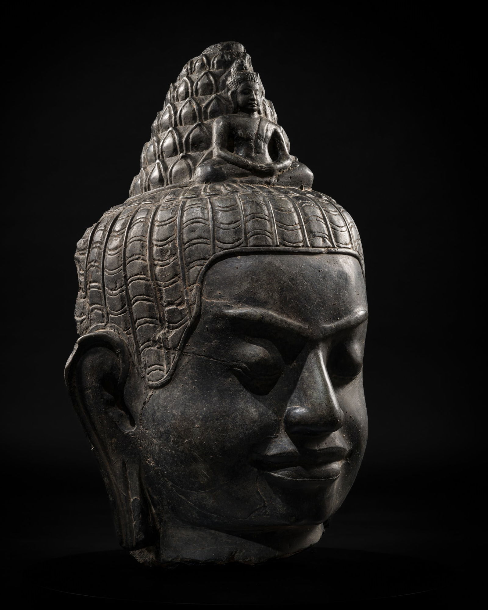 A LARGE BLACK LACQUERED STONE HEAD OF BODHISATTVA AVALOKITESHVARA, LOPBURI STYLE, 12TH-13TH CENTURY: A LARGE BLACK LACQUERED STONE HEAD OF BODHISATTVA AVALOKITESHVARA, LOPBURI STYLE, 12TH-13TH CENTURY This lot is from a single owner collection and is therefore offered without reserve Exhibited: