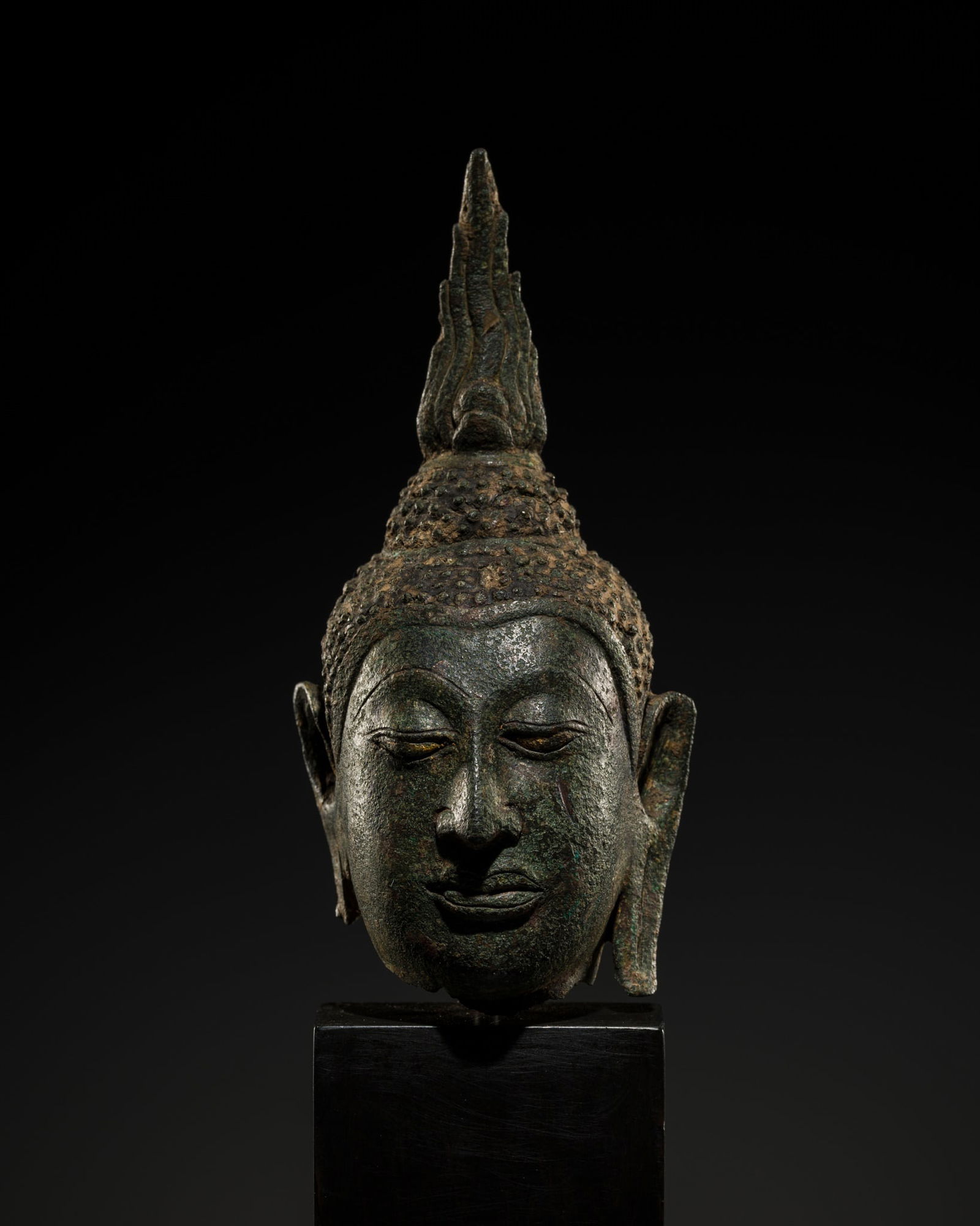 A SMALL BRONZE HEAD OF SHAKYAMUNI, SUKHOTHAI STYLE, AYUTTHAYA PERIOD: A SMALL BRONZE HEAD OF SHAKYAMUNI, SUKHOTHAI STYLE, AYUTTHAYA PERIOD This lot is from a single owner collection and is therefore offered without reserve Thailand, circa 15th-16th ce