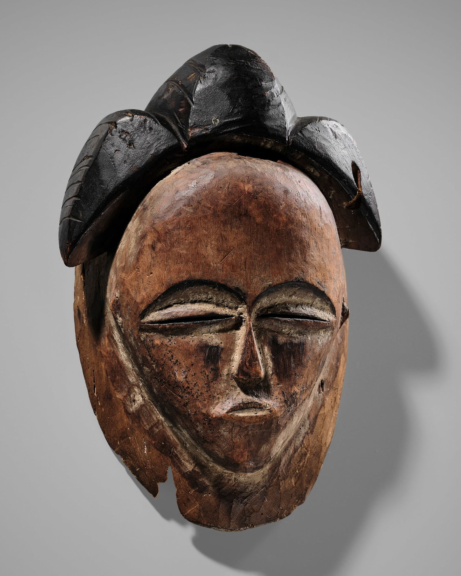 A POLYCHROME WOOD PUNU MASK, OKUYI, 18TH-19TH CENTURY (1 of 19)