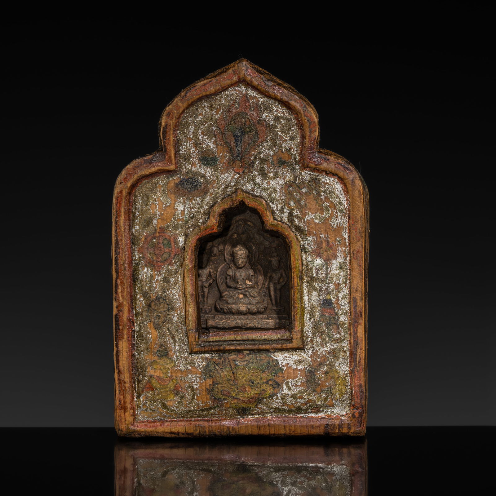 A PAINTED WOOD PORTABLE SHRINE WITH A TERRACOTTA TSA-TSA, GAU, 18TH-19TH CENTURY: A PAINTED WOOD PORTABLE SHRINE WITH A TERRACOTTA TSA-TSA, GAU, 18TH-19TH CENTURY This lot is from a single owner collection and is therefore offered without reserve Tibet. The shrine is of lobed outli