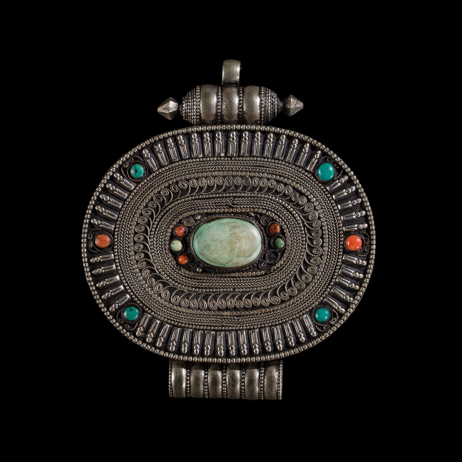 A LARGE TURQUOISE AND CORAL INLAID SILVER AND COPPER AMULET BOX, GAU, 19TH CENTURY: A LARGE TURQUOISE AND CORAL INLAID SILVER AND COPPER AMULET BOX, GAU, 19TH CENTURY This lot is from a single owner collection and is therefore offered without reserve Tibet. Of oval form, the front is