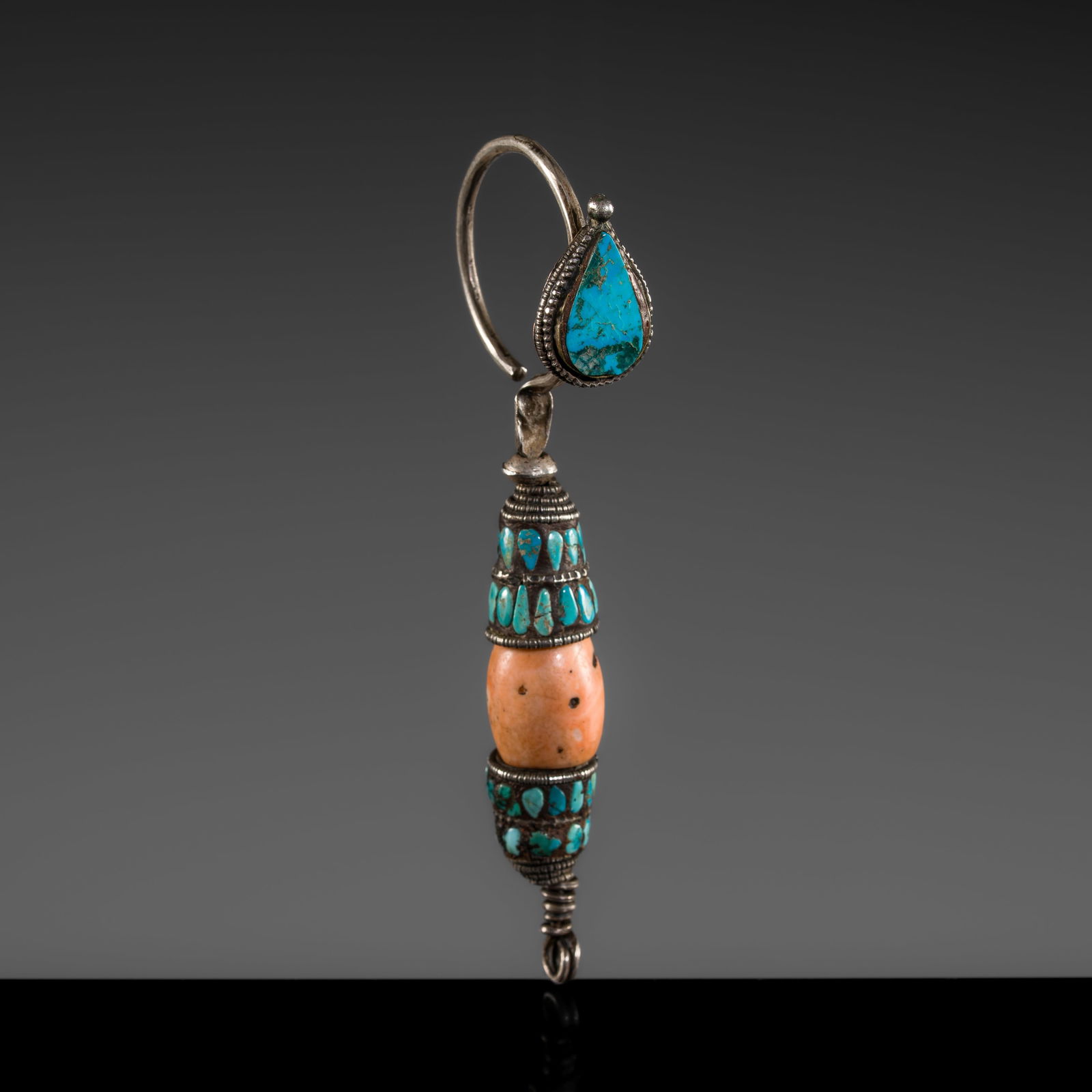 A FINE CORAL AND TURQUOISE SILVER EARRING, 19TH CENTURY: A FINE CORAL AND TURQUOISE SILVER EARRING, 19TH CENTURY This lot is from a single owner collection and is therefore offered without reserve Tibet. The elongated earring with a C-shaped hoop, inlaid wi
