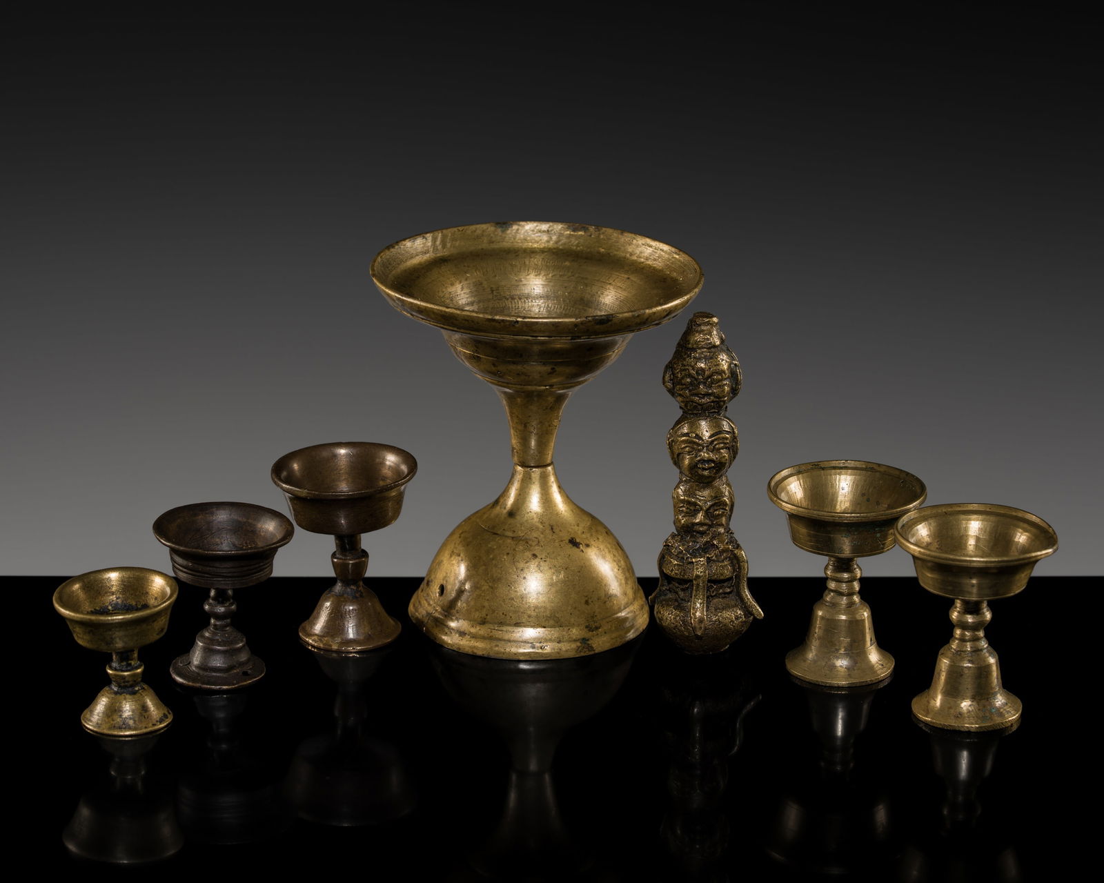 A GROUP OF SIX BRASS BUTTER LAMPS AND A THREE-HEADED BRASS FIGURE, 19TH-20TH CENTURY AND EARLIER (1 of 13)