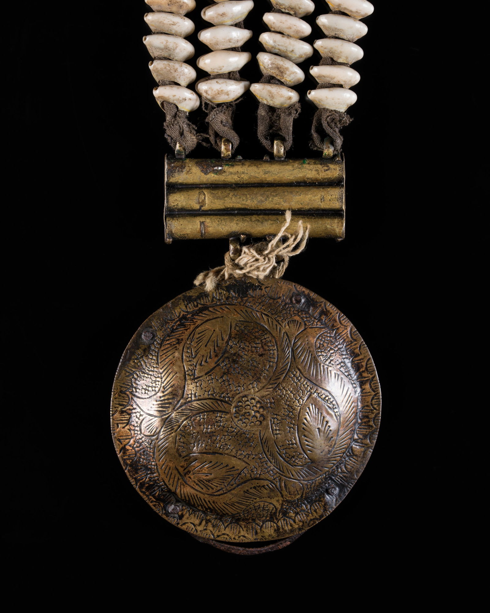 A COWRIE SHELL AND BRASS DODCHA (BELT ORNAMENT), EARLY 20TH CENTURY: A COWRIE SHELL AND BRASS DODCHA (BELT ORNAMENT), EARLY 20TH CENTURY This lot is from a single owner collection and is therefore offered without reserve North India, Ladakh. Consisting of four strands,