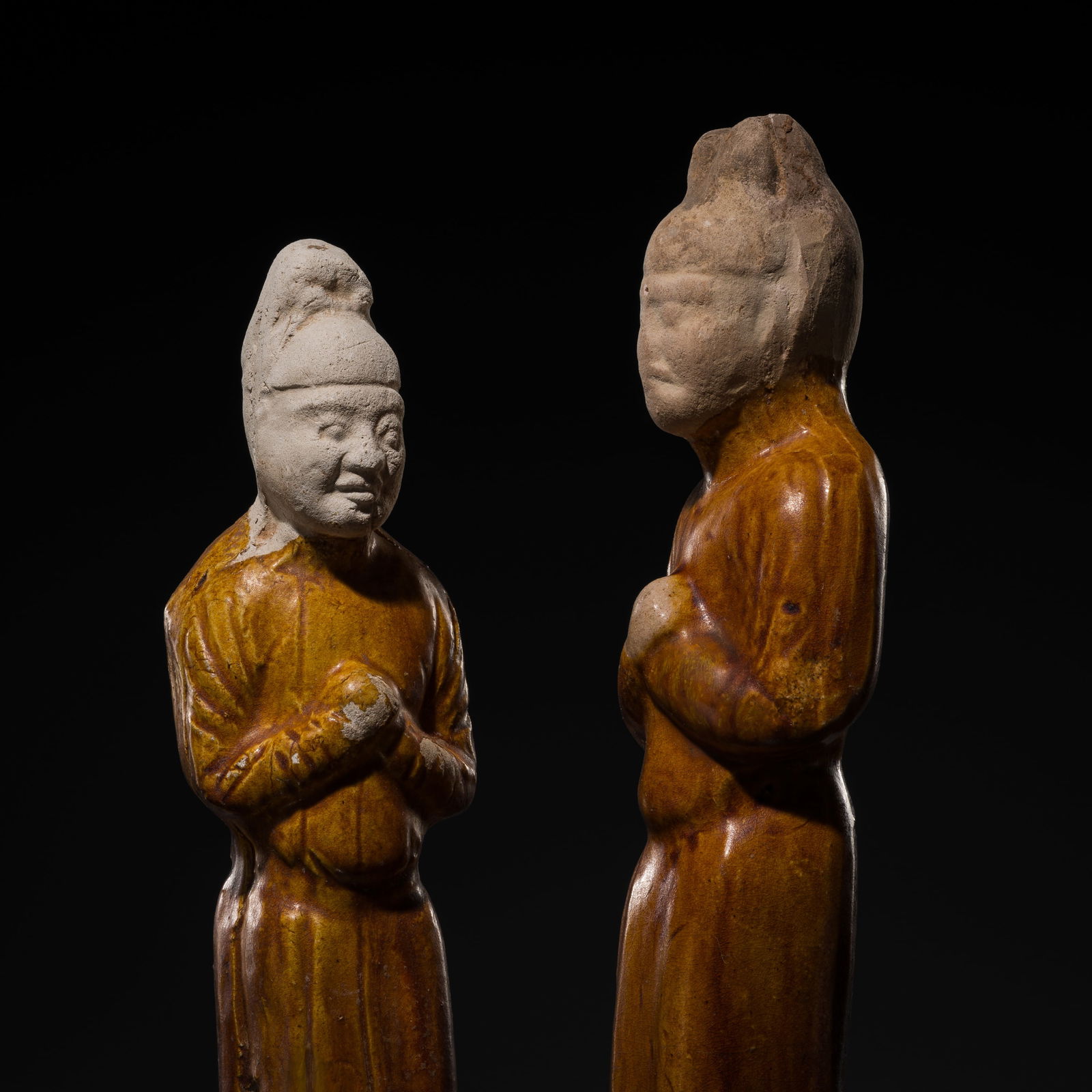 A PAIR OF AMBER-GLAZED POTTERY FIGURES OF OFFICIALS, TANG DYNASTY (1 of 14)