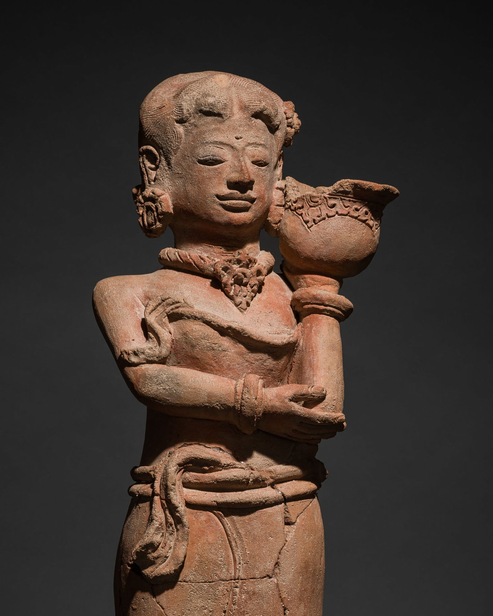 A MAJAPAHIT TERRACOTTA FIGURE OF A GIRL CARRYING A BOWL: A MAJAPAHIT TERRACOTTA FIGURE OF A GIRL CARRYING A BOWL This lot is from a single owner collection and is therefore offered without reserve Published: Editor Paolo Ber