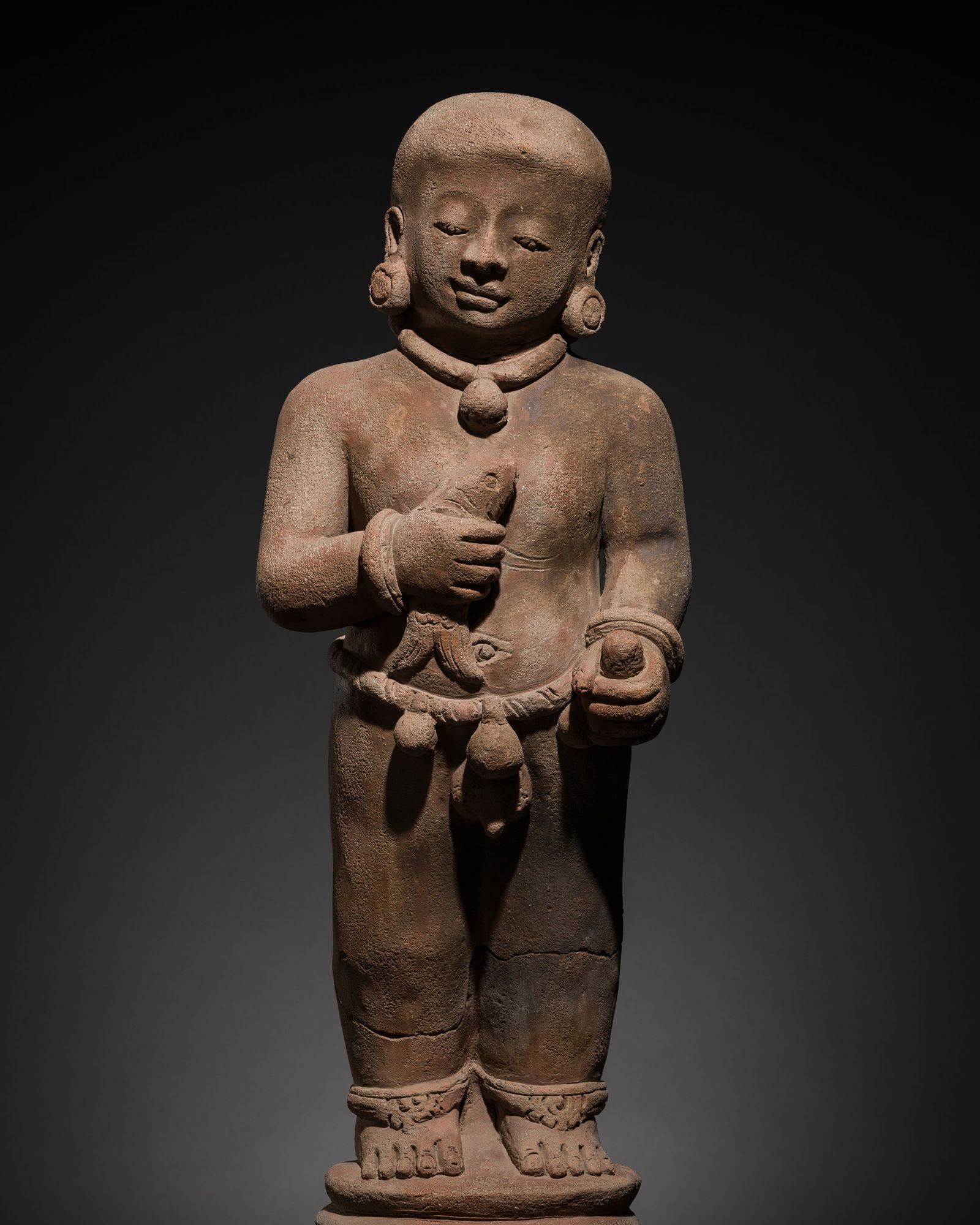 A MAJAPAHIT TERRACOTTA FIGURE OF A BOY HOLDING A FISH: A MAJAPAHIT TERRACOTTA FIGURE OF A BOY HOLDING A FISH This lot is from a single owner collection and is therefore offered without reserve Published: Editor Paolo Bertu