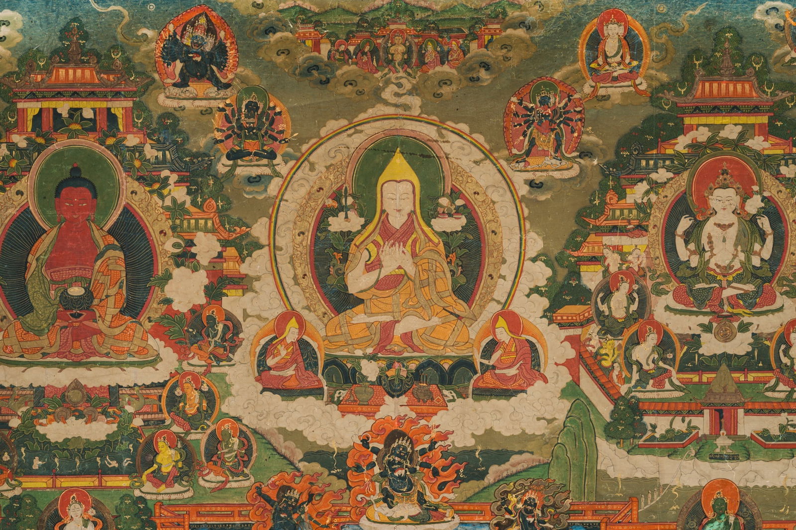 A LARGE HORIZONTAL THANGKA OF TSONGKHAPA WITH BUDDHA AMITABHA AND CHATURBHUJA AVALOKITESHVARA,: A LARGE HORIZONTAL THANGKA OF TSONGKHAPA WITH BUDDHA AMITABHA AND CHATURBHUJA AVALOKITESHVARA, 18TH-19TH CENTURY Gold and distemper on cloth. The three main deities are each seated in dhyanasana on lo