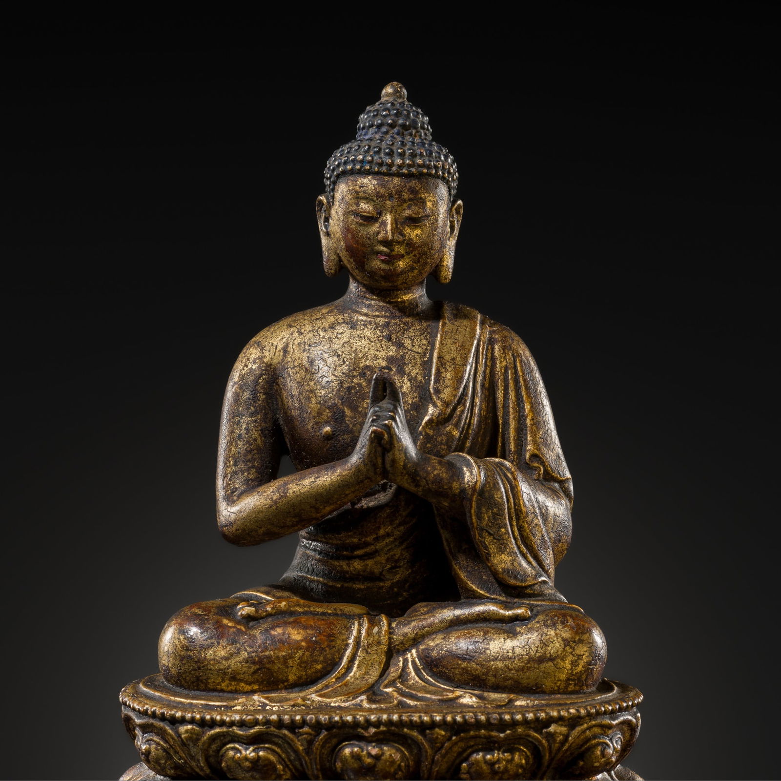 A RARE GILT-LACQUERED CLAY FIGURE OF BUDDHA VAIROCANA, MING DYNASTY: A RARE GILT-LACQUERED CLAY FIGURE OF BUDDHA VAIROCANA, MING DYNASTY Tibetan-Chinese, 15th-16th century. Seated in dhyanasana on a double lotus base with beaded rims, the hands folded in abhiseka mudra