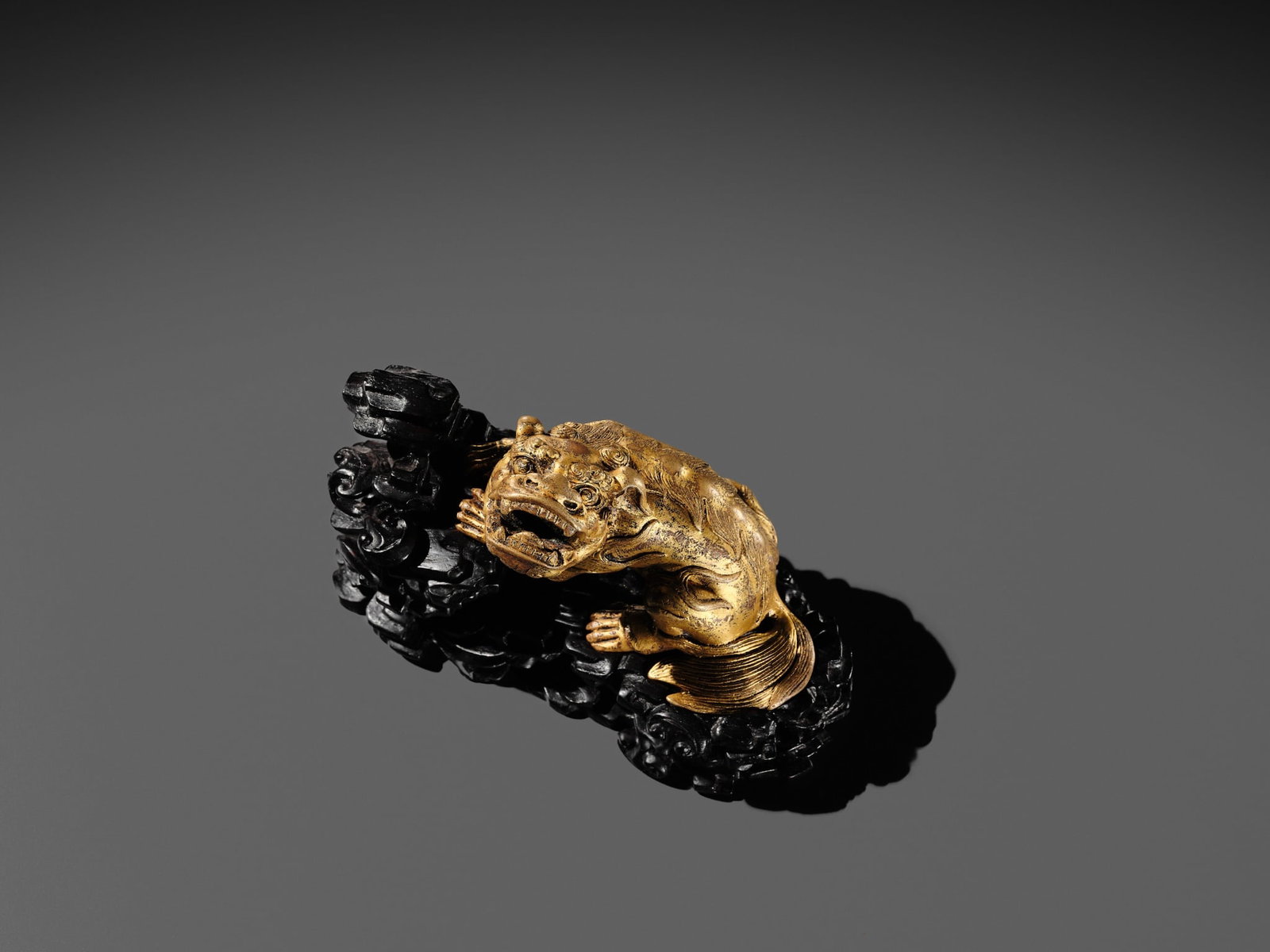 A GILT BRONZE 'LION' WEIGHT WITH A MATCHING ZITAN BASE, CHINA, 16TH-17TH CENTURY - 17
