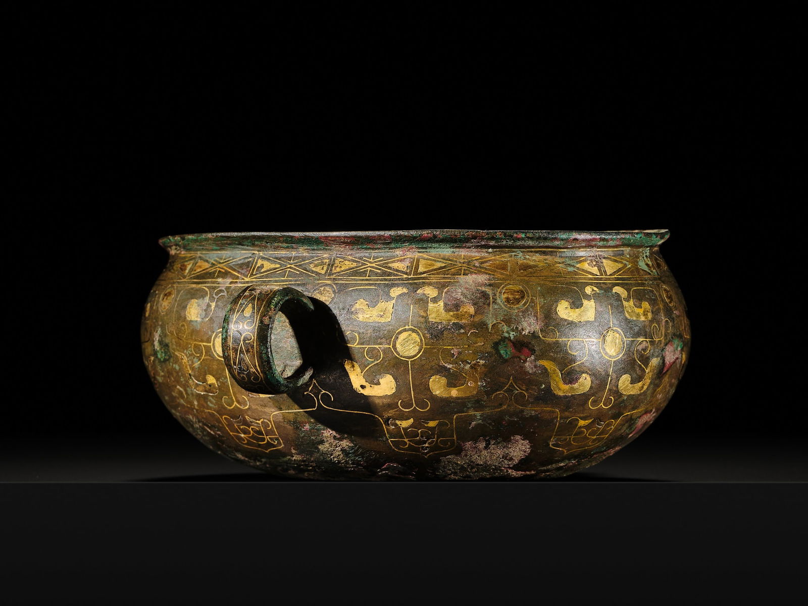 A GOLD-INLAID BRONZE EAR CUP, DUN, LATE SPRING AND AUTUMN PERIOD TO EARLY TO WESTERN HAN DYNASTY: A GOLD-INLAID BRONZE EAR CUP, DUN, LATE SPRING AND AUTUMN PERIOD TO EARLY TO WESTERN HAN DYNASTY China, circa 5th-2nd century BC. Of oval section, flanked by a pair of loop handles, the slightly waist