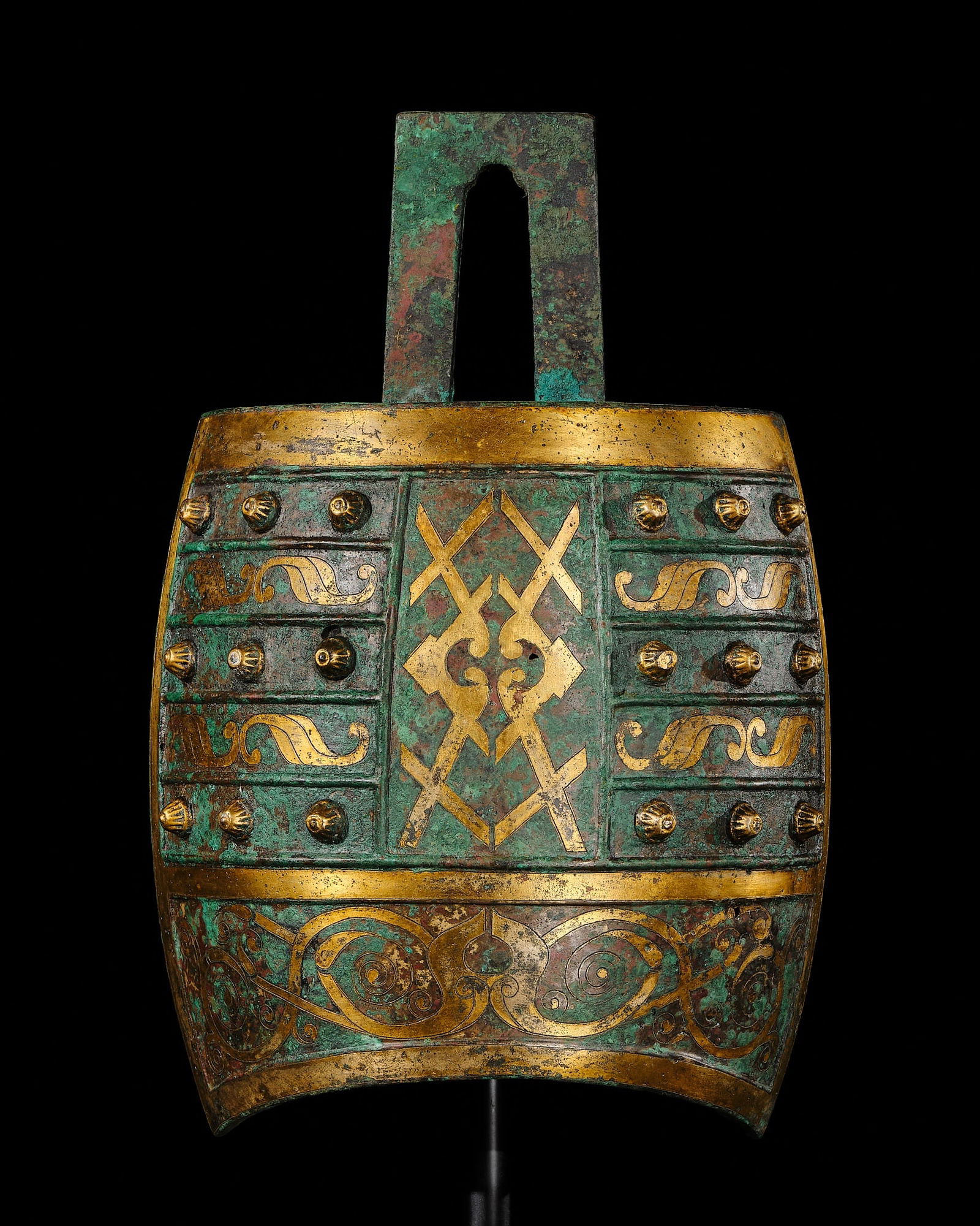A PARCEL-GILT AND INCISED BRONZE BELL, NIUZHONG, WESTERN HAN DYNASTY: A PARCEL-GILT AND INCISED BRONZE BELL, NIUZHONG, WESTERN HAN DYNASTY China, 1st century BC. The oval body is surmounted by an arched handle and rests on a curving lower rim. Each side is applied with