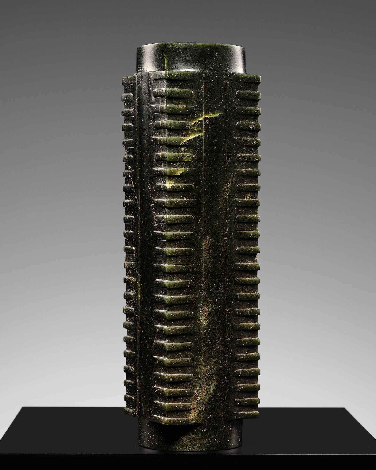 AN EXCEEDINGLY RARE ELEVEN-TIERED DARK GREEN JADE CONG, LIANGZHU CULTURE: AN EXCEEDINGLY RARE ELEVEN-TIERED DARK GREEN JADE CONG, LIANGZHU CULTURE China, c. 3300-2200 BC. Of cylindrical form with square projections on four corners, each corner carved with raised bands, a lo