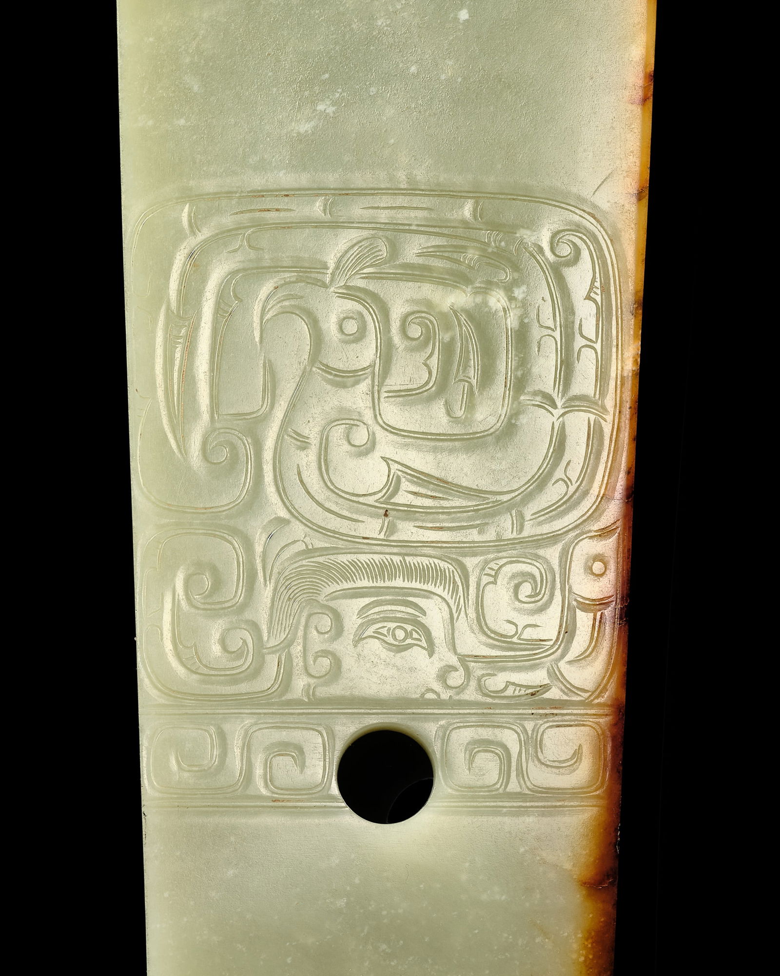A GREEN AND RUSSET JADE 'HUMAN AND BIRD' CEREMONIAL BLADE, WESTERN ZHOU DYNASTY (1 of 20)