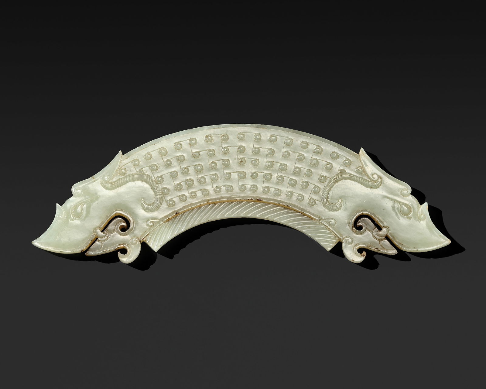 A WHITE JADE 'DOUBLE-DRAGON' PENDANT, HUANG, LATE EASTERN ZHOU-EARLY WESTERN HAN: A WHITE JADE 'DOUBLE-DRAGON' PENDANT, HUANG, LATE EASTERN ZHOU-EARLY WESTERN HAN Expert's note:This huang demonstrates a notable degree of complexity in both conception and execution, distinguished by