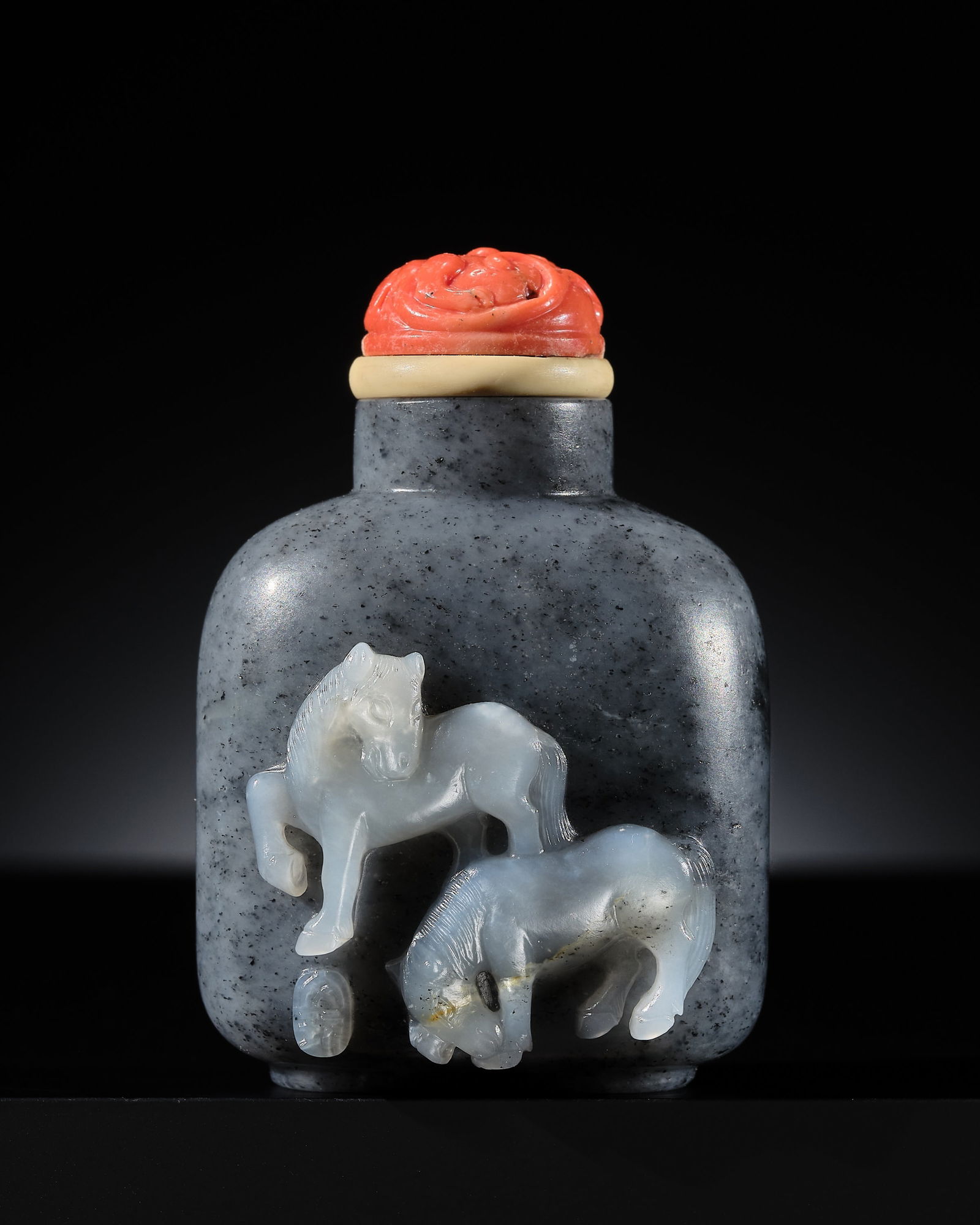 AN INSCRIBED BLACK AND WHITE JADE 'HORSES' SNUFF BOTTLE, SUZHOU SCHOOL, 1740-1860: AN INSCRIBED BLACK AND WHITE JADE 'HORSES' SNUFF BOTTLE, SUZHOU SCHOOL, 1740-1860 China. Well hollowed, the stout rounded rectangular body supported on a short oval foot and rising to a cylindrical ne