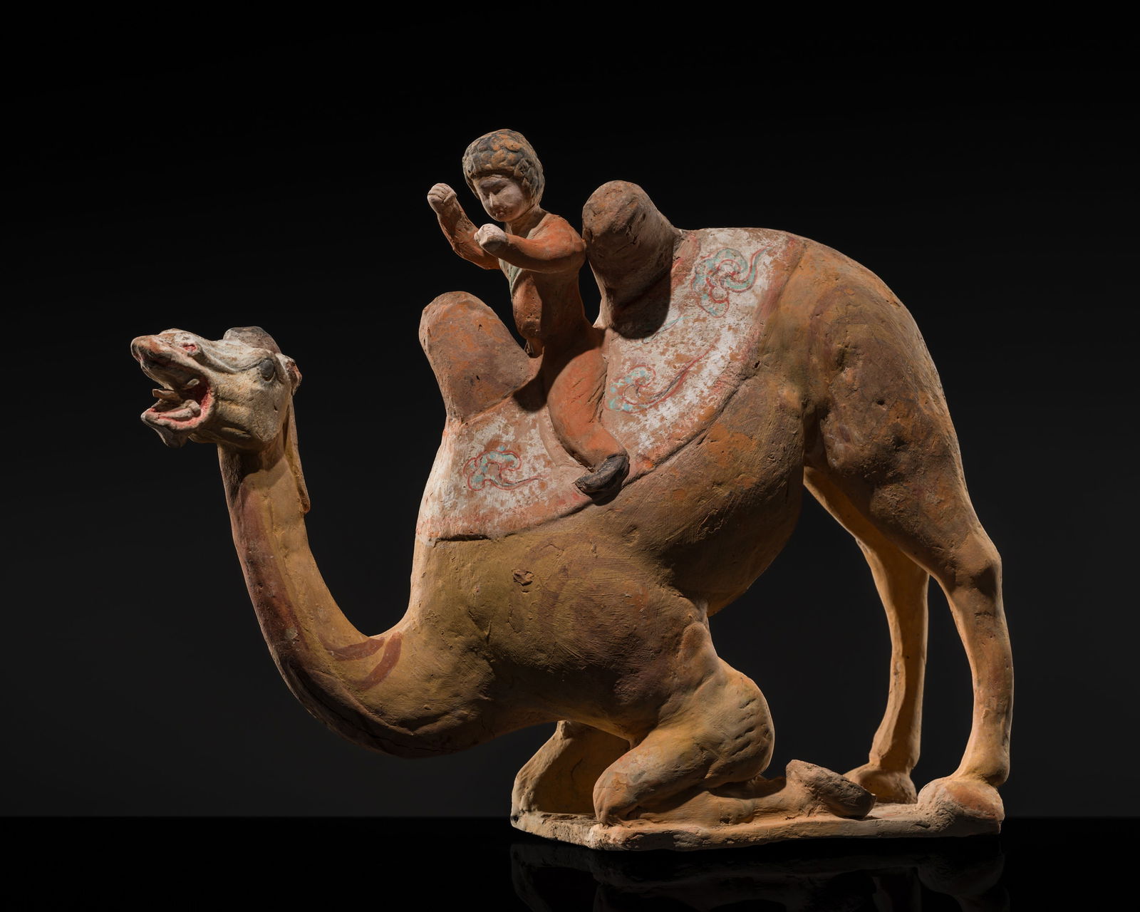 A RARE AND FINELY PAINTED POTTERY GROUP OF A KNEELING CAMEL AND FOREIGN RIDER, TANG DYNASTY (1 of 19)