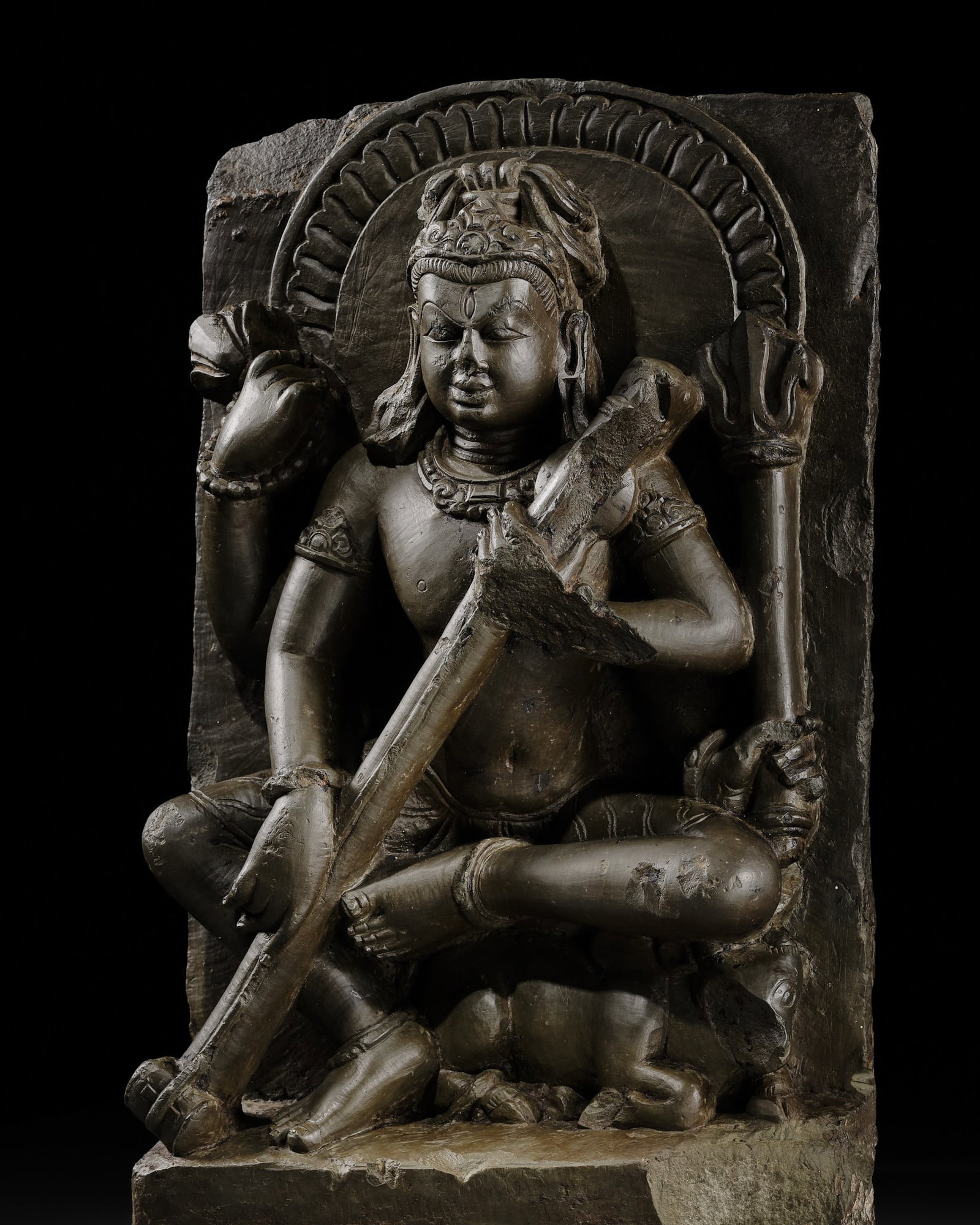 A GREENISH-GRAY SCHIST STELE OF SHIVA PLAYING THE VINA, ALMORA, 10TH-11TH CENTURY: A GREENISH-GRAY SCHIST STELE OF SHIVA PLAYING THE VINA, ALMORA, 10TH-11TH CENTURY Published & Exhibited: Pratapaditya Pal, A Collecting Odyssey: Indian, Himalayan and Southeast Asian Art from the