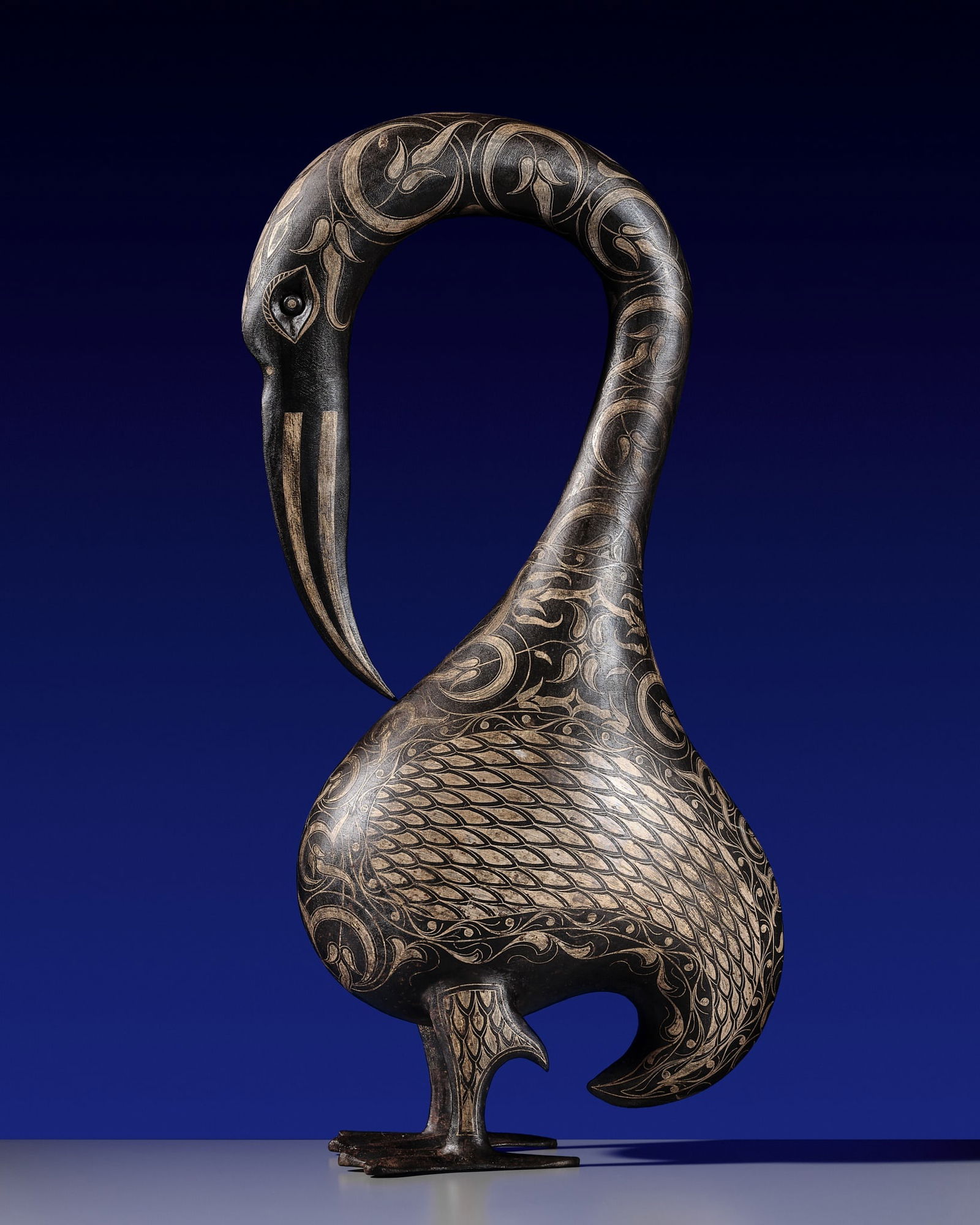 A LARGE SILVER DAMASCENED IRON FIGURE OF A WATERFOWL, PERSIA, QAJAR, 18TH-19TH CENTURY: A LARGE SILVER DAMASCENED IRON FIGURE OF A WATERFOWL, PERSIA, QAJAR, 18TH-19TH CENTURY An elegant body with a long, curving neck terminating in a slender beak, set on two sturdy feet and finished with