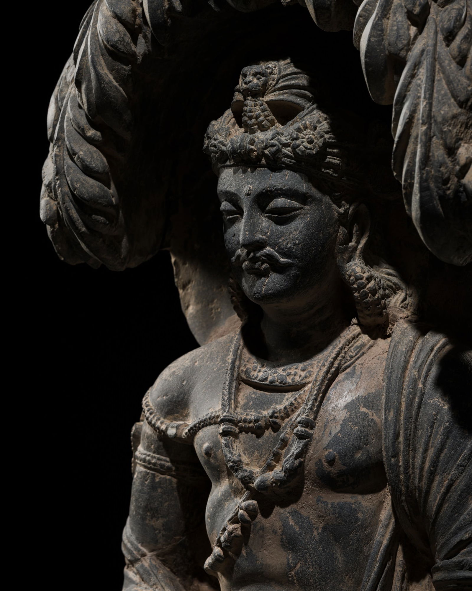 A GRAY SCHIST FIGURE OF GAUTAMA SIDDHARTHA MEDITATING UNDER THE JAMBU TREE, ANCIENT REGION OF (1 of 20)