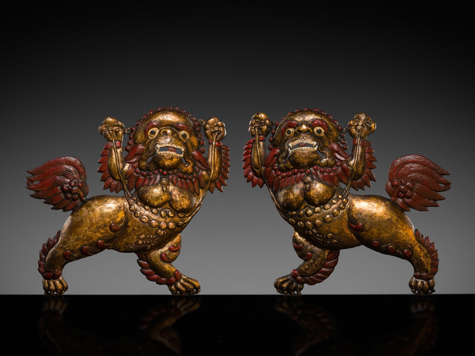 A PAIR OF GILT COPPER REPOUSSÉ SNOW LIONS, TIBET, 17TH-18TH CENTURY: A PAIR OF GILT COPPER REPOUSSÉ SNOW LIONS, TIBET, 17TH-18TH CENTURY Each finely hammered and expressively modeled in mirror image, the pair poised in dynamic confrontation upon sharp claws. Their
