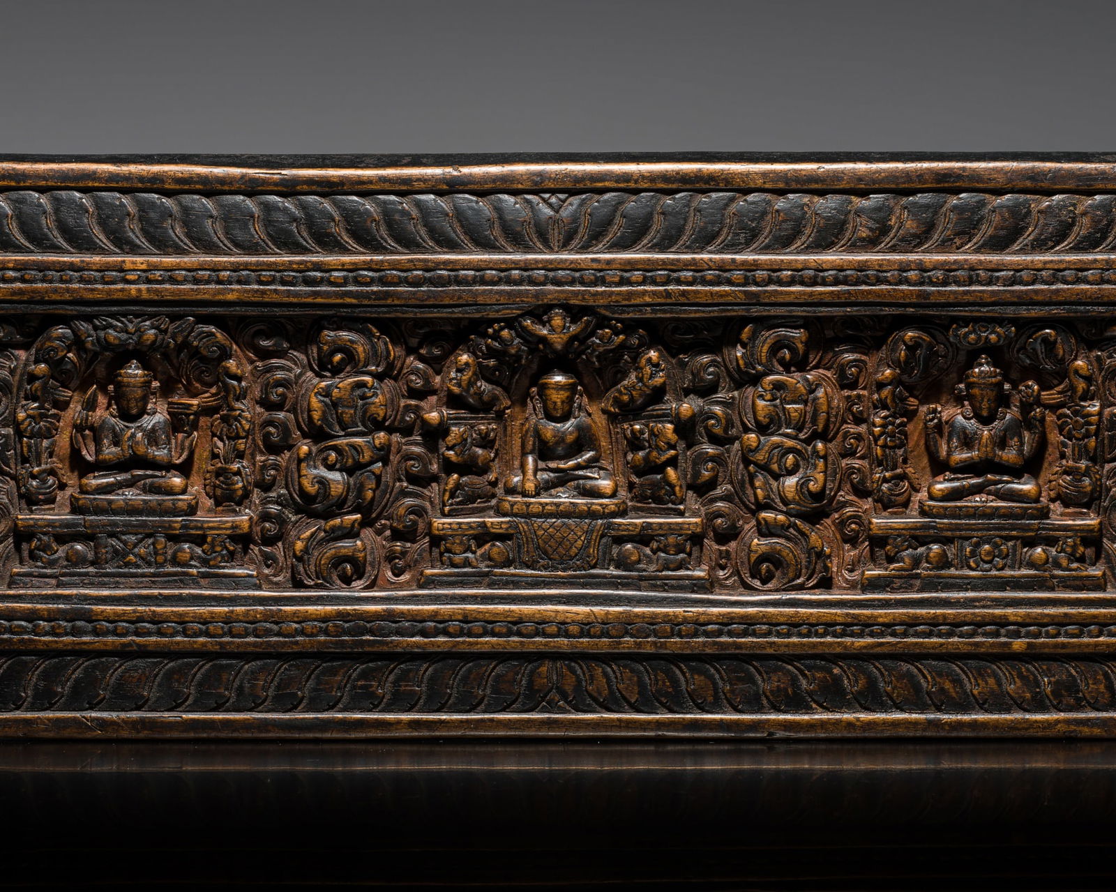 A WOOD MANUSCRIPT COVER WITH BUDDHA, SHADAKSHARI, AND PRAJNAPARAMITA, TIBET, 14TH-15TH CENTURY: A WOOD MANUSCRIPT COVER WITH BUDDHA, SHADAKSHARI, AND PRAJNAPARAMITA, TIBET, 14TH-15TH CENTURY Finely carved in varying degrees of relief, depicting Buddha Shakyamuni at the center with his right hand