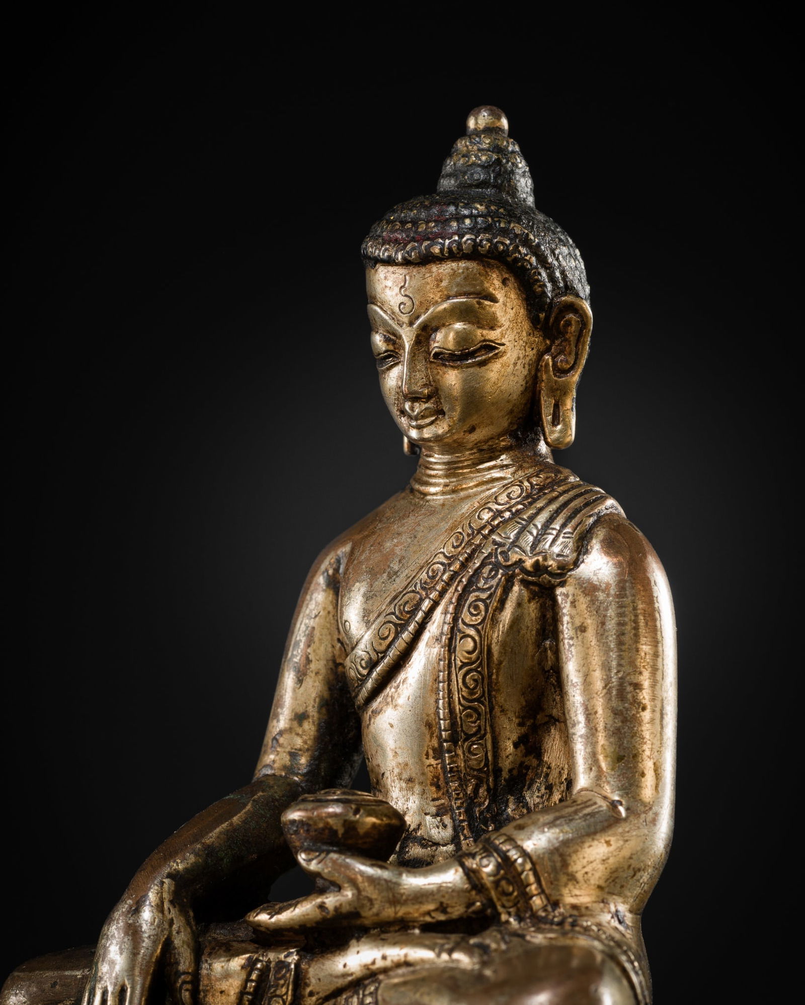 A SILVERED COPPER ALLOY FIGURE OF BUDDHA SHAKYAMUNI, NEPAL, 18TH-19TH CENTURY OR EARLIER (1 of 12)