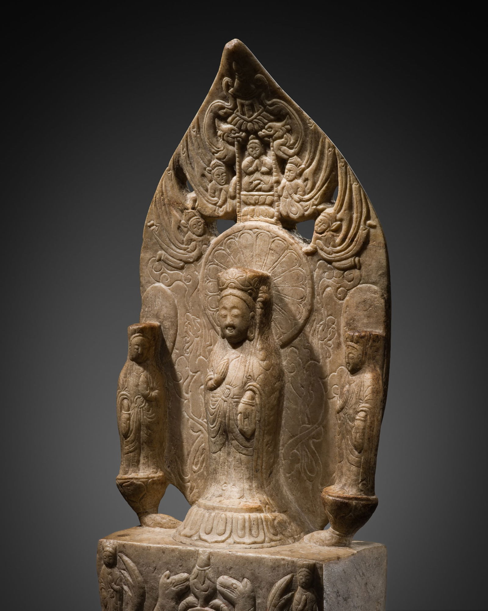 A WHITE MARBLE VOTIVE STELE OF THE AMITABHA TRIAD, DATED BY INSCRIPTION TO 559 AD: A WHITE MARBLE VOTIVE STELE OF THE AMITABHA TRIAD, DATED BY INSCRIPTION TO 559 AD Expert's Note:The inscription records that the statue was commissioned on the fifteenth day of the twelfth month of th