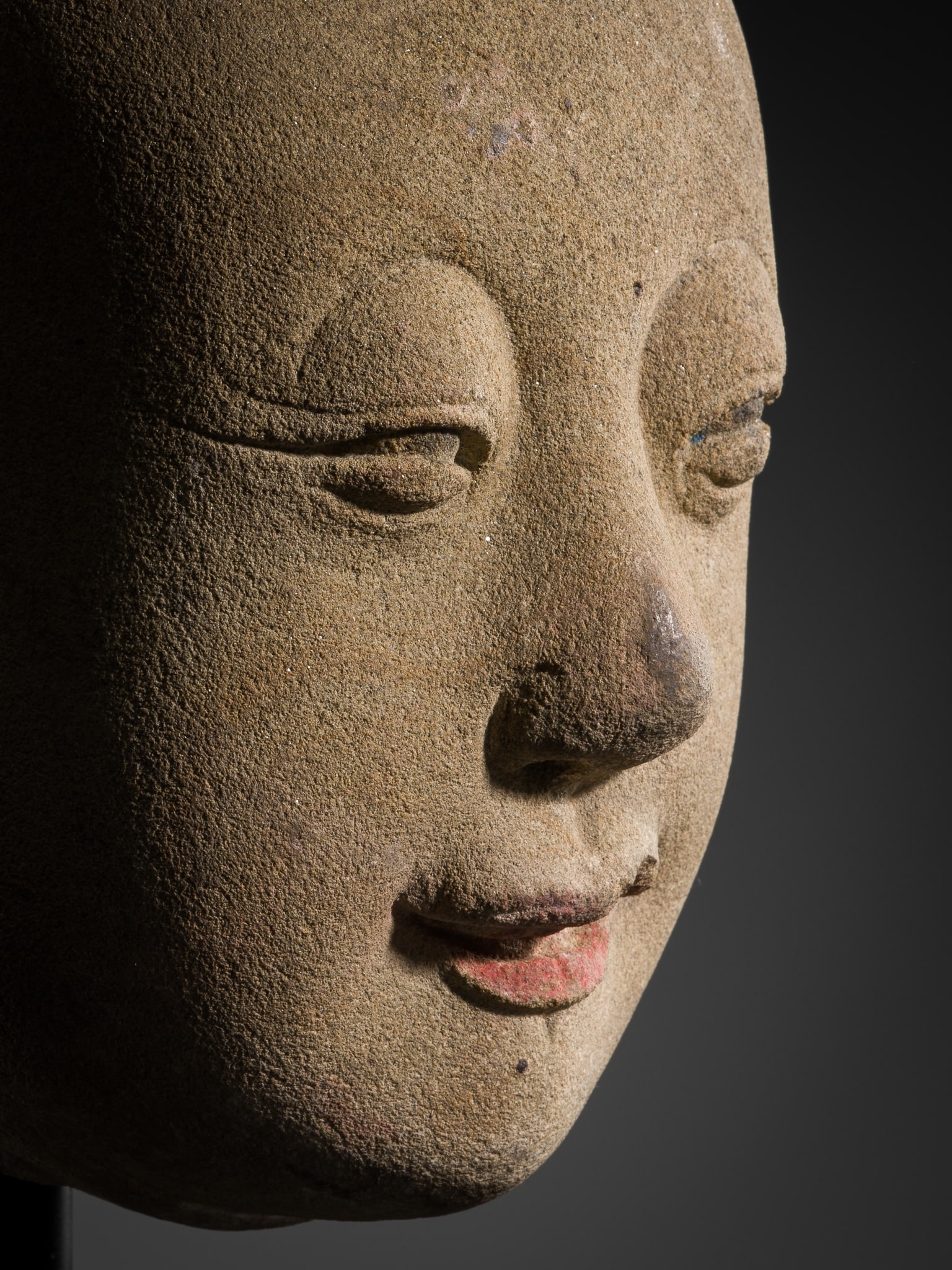 AN EXCEPTIONALLY RARE AND EARLY STONE HEAD OF A YOUTHFUL LUOHAN, TANG DYNASTY (618-907) (1 of 14)