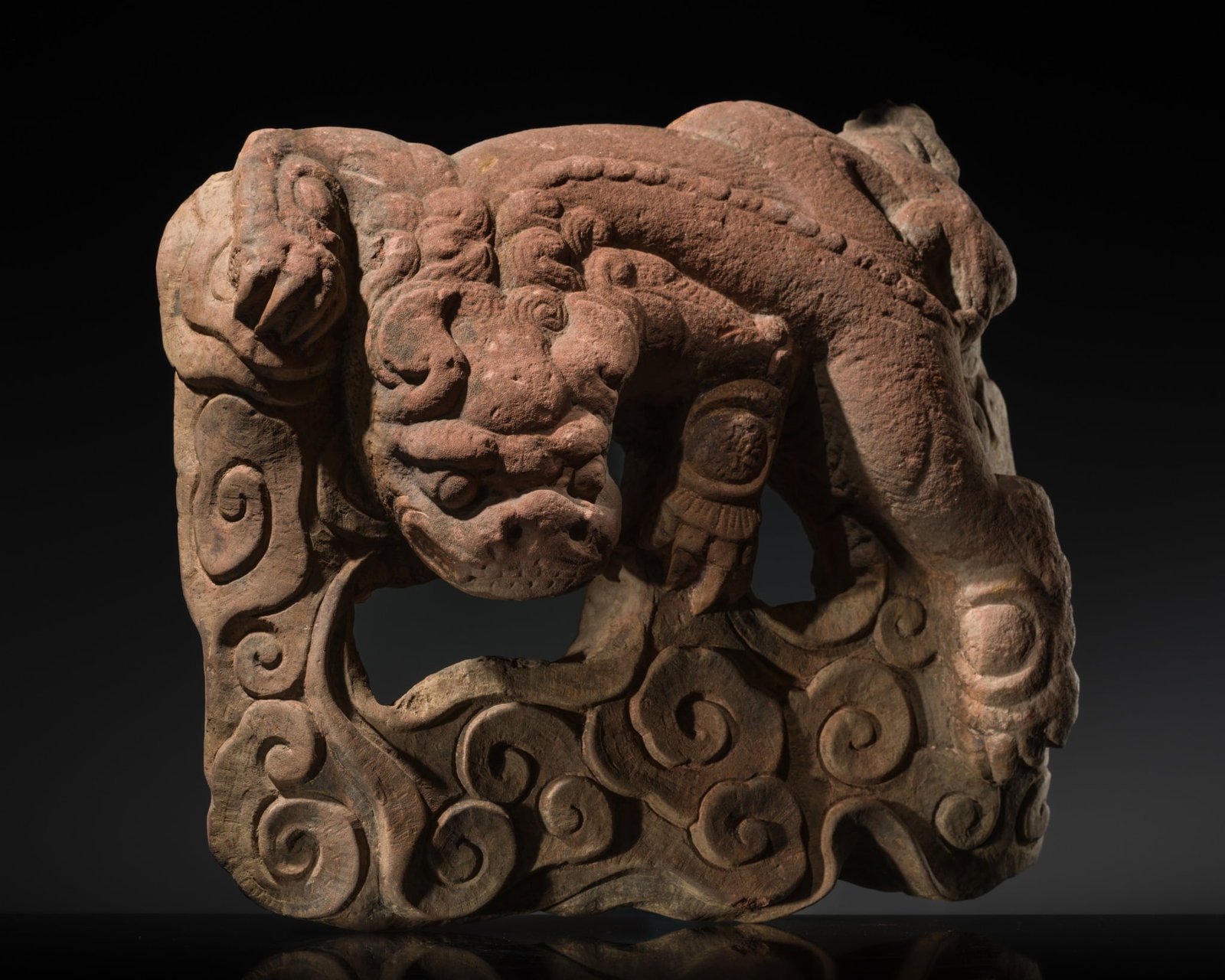 A RED SANDSTONE OPENWORK STELE WITH A GUARDIAN LION, MING DYNASTY: A RED SANDSTONE OPENWORK STELE WITH A GUARDIAN LION, MING DYNASTY Expert's note: The carefully carved apertures within the piece suggest that it may have been designed to allow steam or incense smoke
