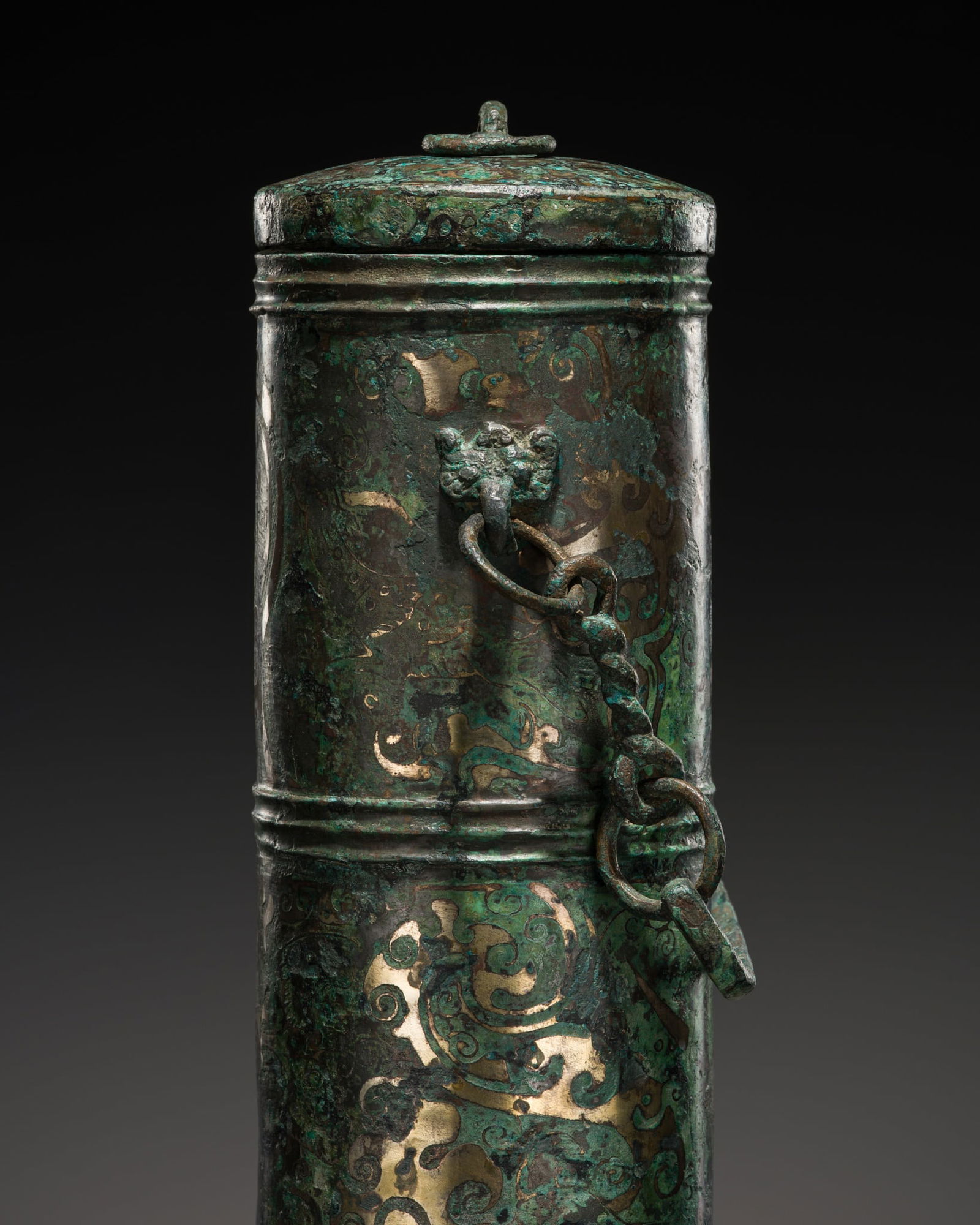 A RARE SILVER-INLAID BRONZE VESSEL AND COVER, HAN DYNASTY: A RARE SILVER-INLAID BRONZE VESSEL AND COVER, HAN DYNASTY China, 206 BC-220 AD. Finely cast, the cylindrical body is richly inlaid in silver alloy and crisply incised with two horizontal registers enc