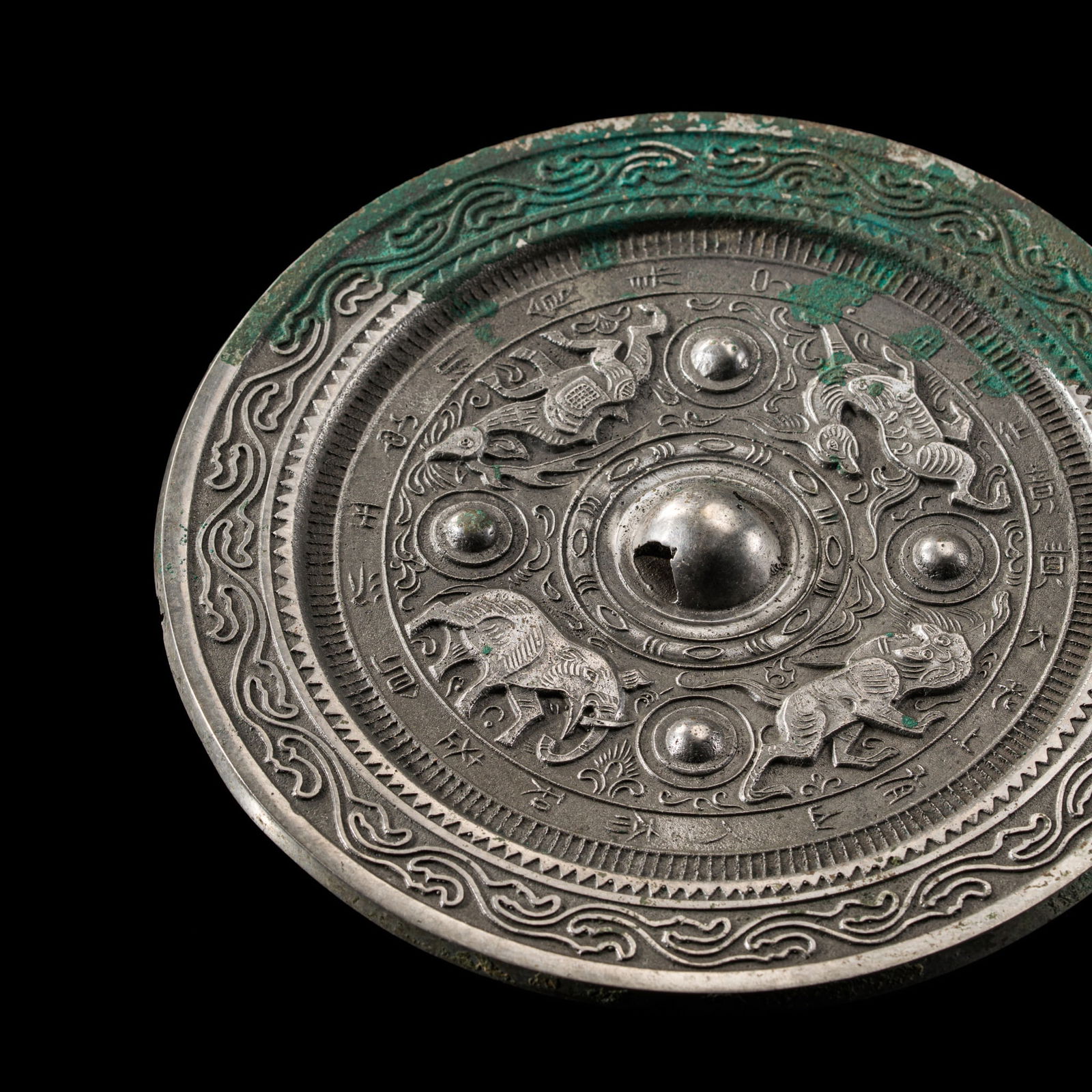 AN INSCRIBED SILVERED BRONZE 'BEASTS AND ANIMALS' MIRROR, EASTERN HAN DYNASTY: AN INSCRIBED SILVERED BRONZE 'BEASTS AND ANIMALS' MIRROR, EASTERN HAN DYNASTY China, 1st-2nd century AD. The circular mirror crisply cast to the reverse with an elephant, a tiger, a dragon, and a stag