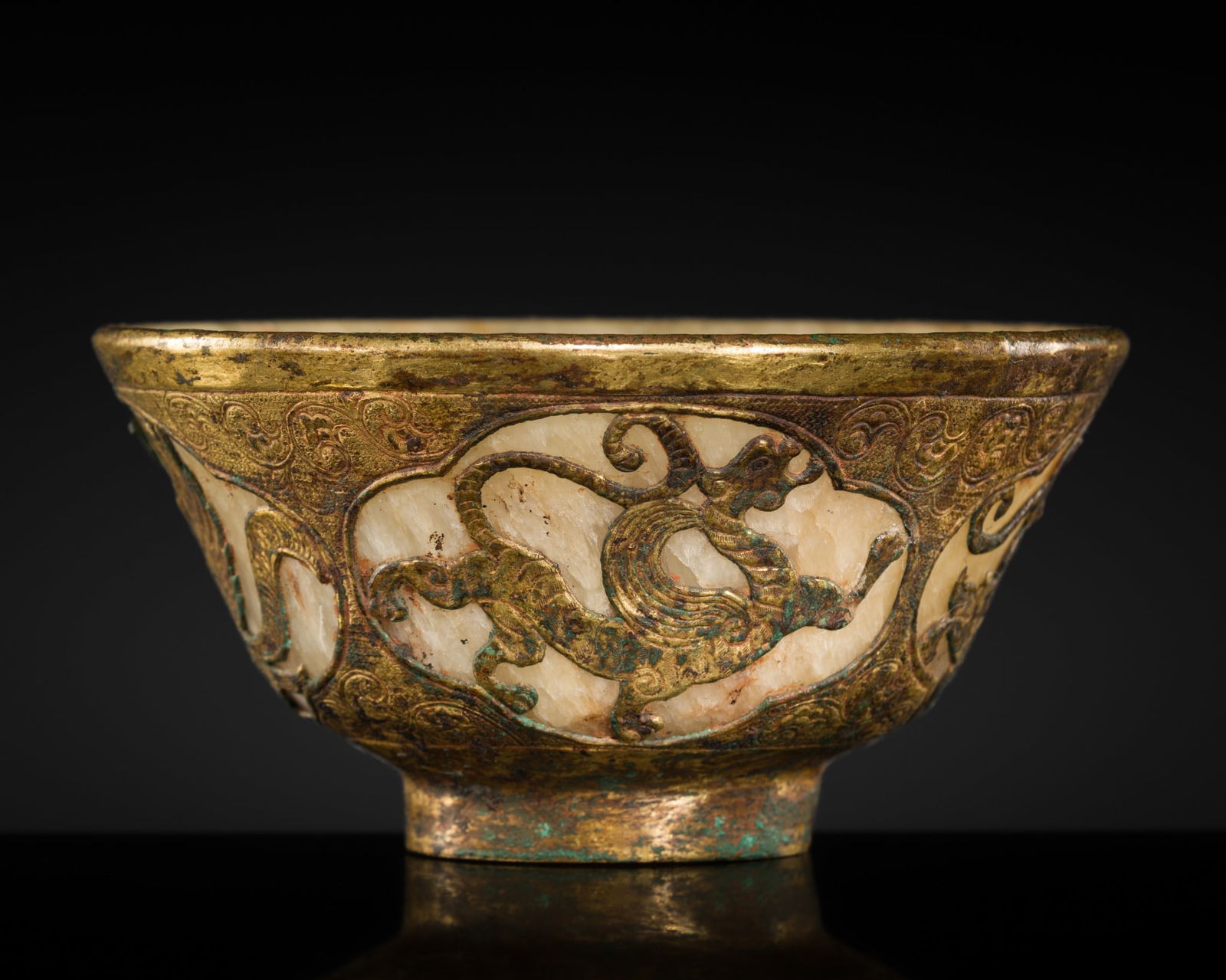A RARE 'FOUR GUARDIANS' GILT-COPPER REPOUSSÉ AND MARBLE BOWL, LIAO DYNASTY: A RARE 'FOUR GUARDIANS' GILT-COPPER REPOUSSÉ AND MARBLE BOWL, LIAO DYNASTY China, 907-1125. Finely carved, with deep, rounded sides rising from a short, straight foot to a gently everted rim. The