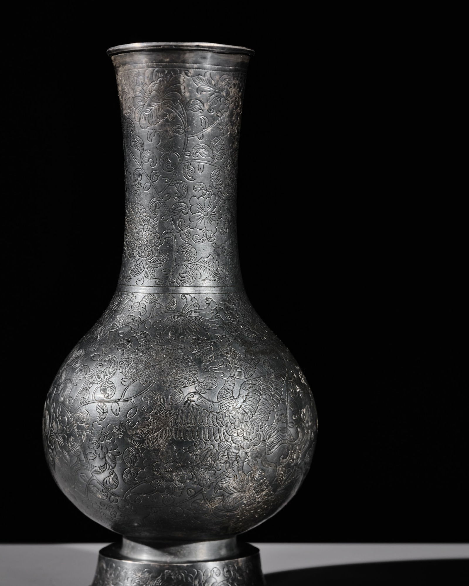 A RARE SILVER 'PHOENIX' BOTTLE VASE, SONG DYNASTY (960-1279): A RARE SILVER 'PHOENIX' BOTTLE VASE, SONG DYNASTY (960-1279) China. Finely modeled, the globular body supported on a spreading foot and rising to a gently waisted neck with slightly flared rim. The ex