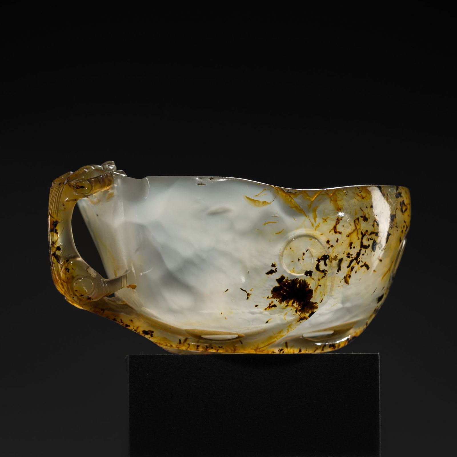 A TRANSLUCENT AGATE 'CHILONG' LIBATION CUP, YUAN TO MING DYNASTY: A TRANSLUCENT AGATE 'CHILONG' LIBATION CUP, YUAN TO MING DYNASTY China, 14th-17th century. Finely worked in the form of a peach, the handle carved as a clambering chilong with its furcated tail servin
