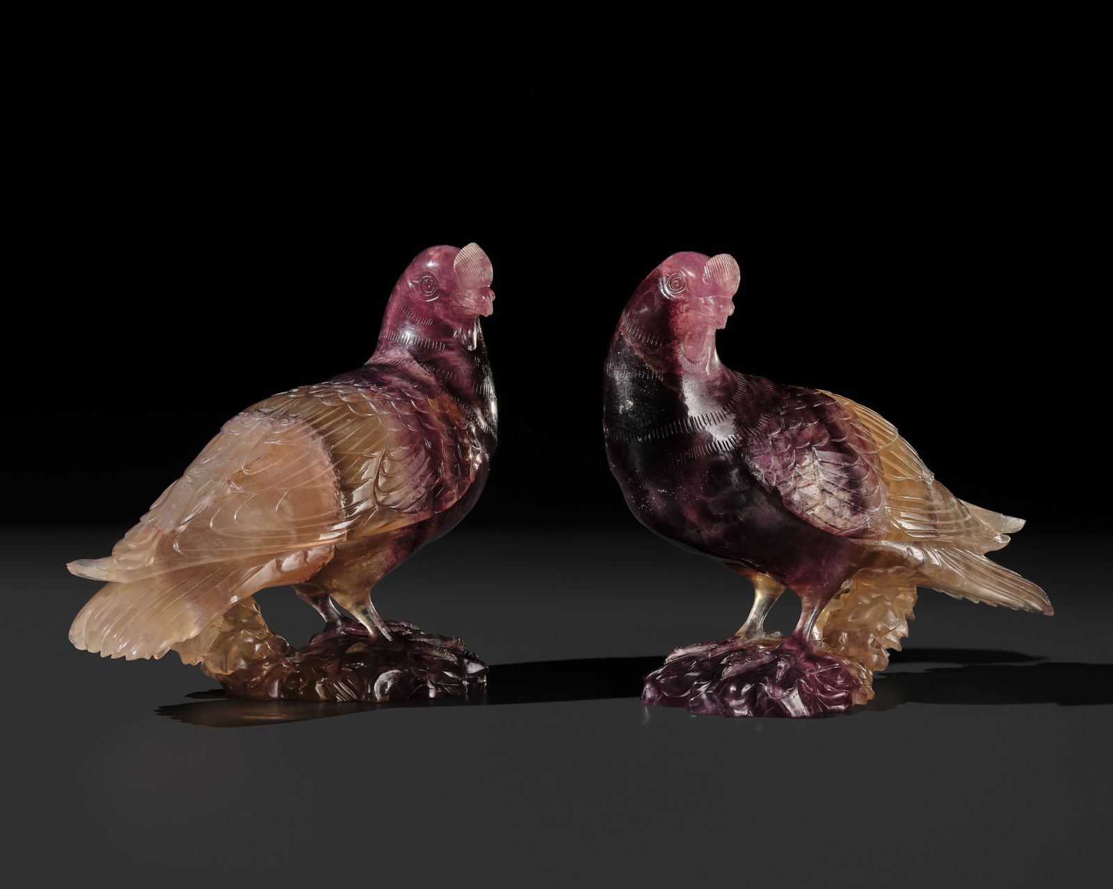 A SUPERB AND UNIQUE PAIR OF AMETHYST DOVES, QIANLONG PERIOD: A SUPERB AND UNIQUE PAIR OF AMETHYST DOVES, QIANLONG PERIOD China, 1736-1795. Naturalistically and finely carved in mirror image, standing on rockwork bases, their heads each turned to the sides, with