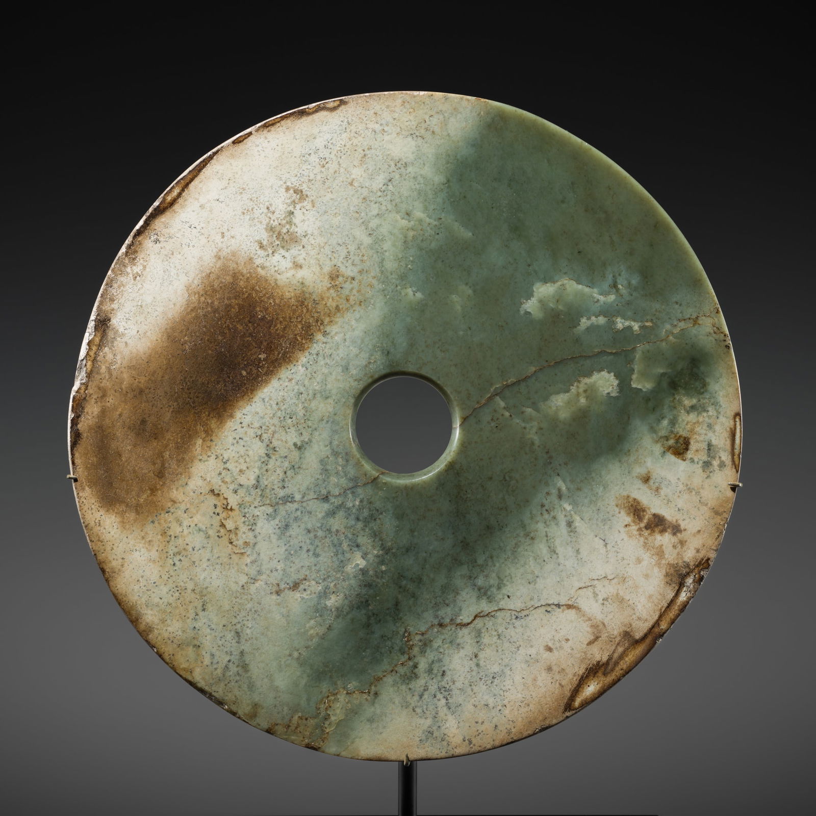 A RARE AND LARGE (33 CM) GREEN JADE DISK, BI, EARLY BRONZE AGE, QIJIA CULTURE: A RARE AND LARGE (33 CM) GREEN JADE DISK, BI, EARLY BRONZE AGE, QIJIA CULTURE Expert authentication: Sam Myers has examined the present lot in 2017 and confirmed its authenticity and the dating above