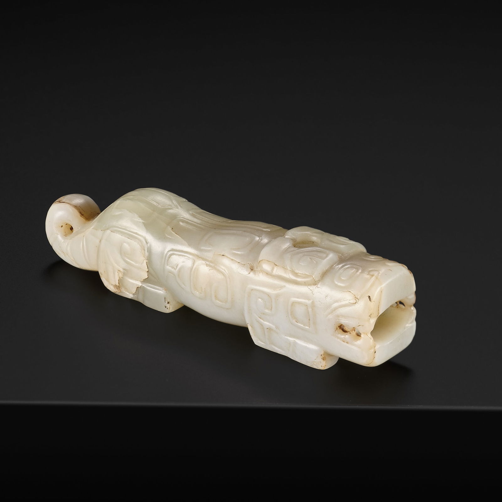 A SUPERB CELADON AND RUSSET JADE FIGURE OF A MYTHICAL TIGER, SHANG DYNASTY: A SUPERB CELADON AND RUSSET JADE FIGURE OF A MYTHICAL TIGER, SHANG DYNASTY China, circa 1600-1046 BC. The two-horned feline beast exquisitely carved crouching on all fours and ready to pounce, the mou