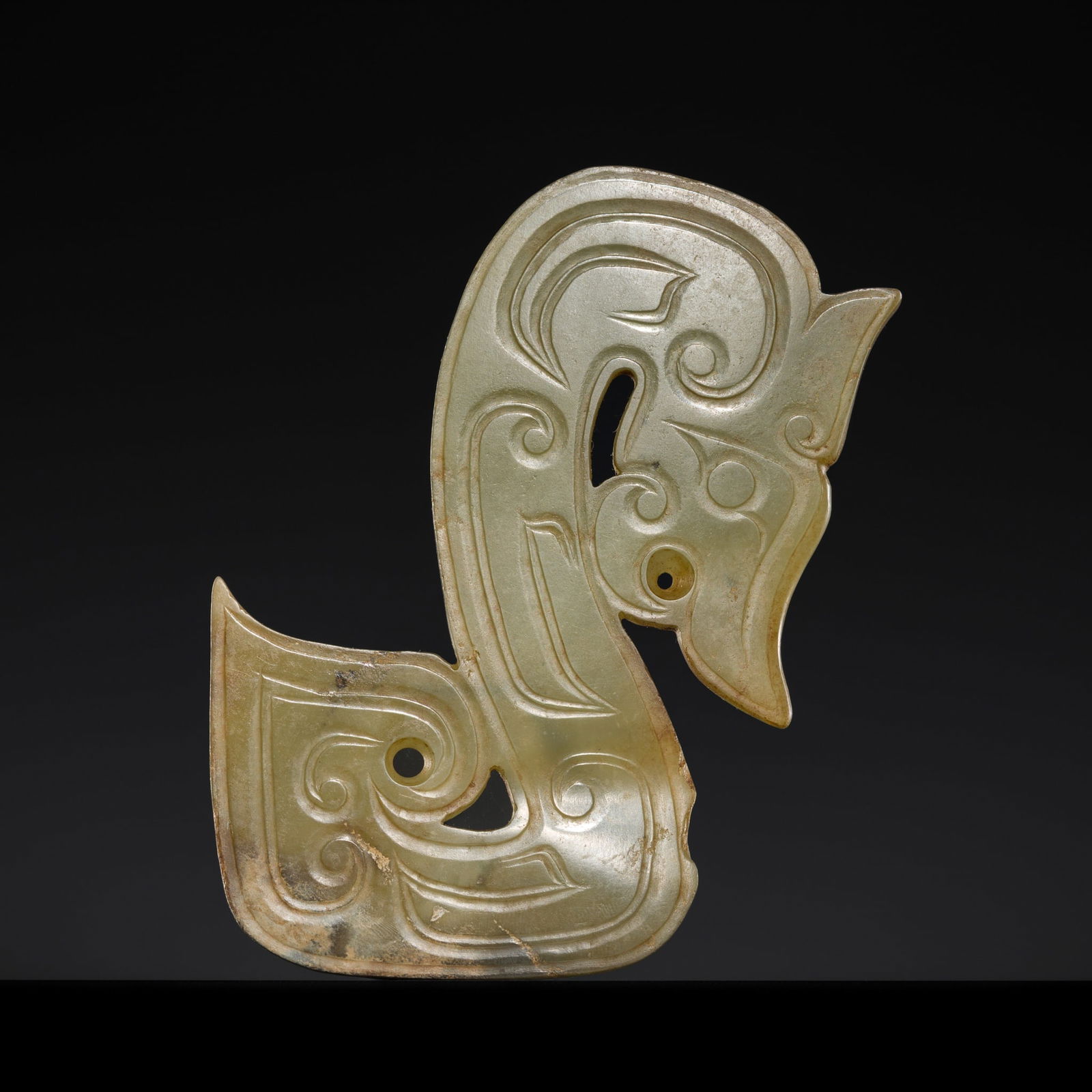 A RARE CELADON JADE 'DRAGON' PENDANT, LATE SHANG DYNASTY: A RARE CELADON JADE 'DRAGON' PENDANT, LATE SHANG DYNASTY Expert authentication: Dr. Gu Fang has examined the present lot and confirms its authenticity and the dating above, noting the style of cutting