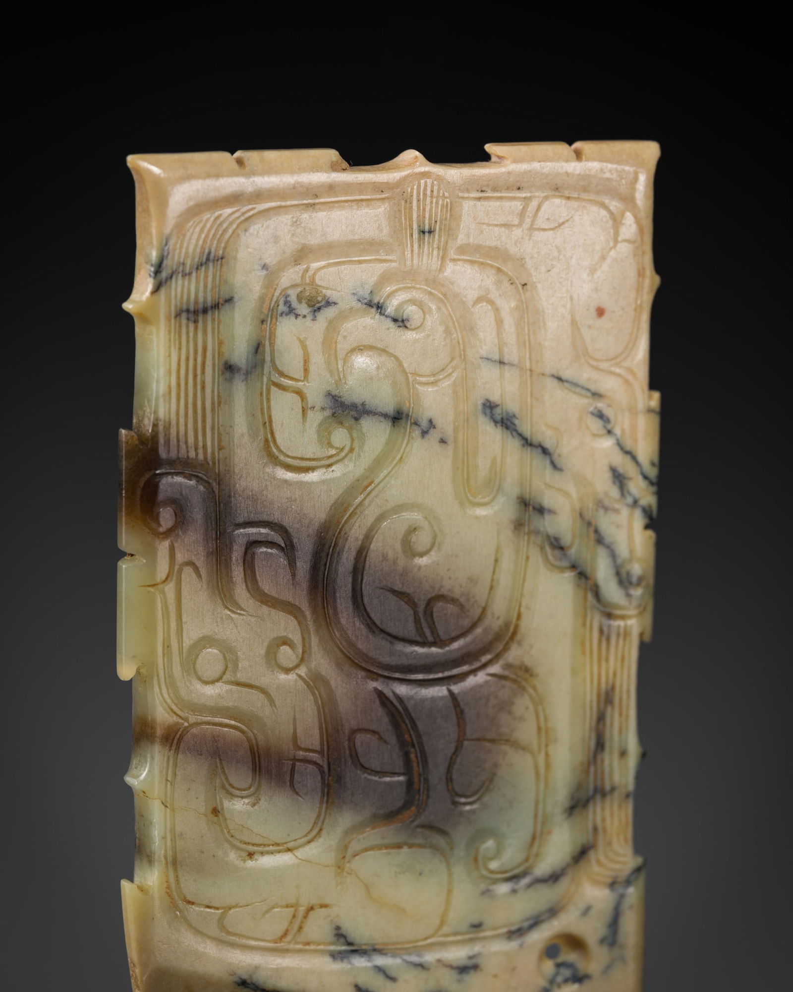 A PALE GREEN AND BROWN JADE 'PHOENIX AND DRAGONS' AXE-SHAPED PENDANT, WESTERN ZHOU DYNASTY (1 of 14)
