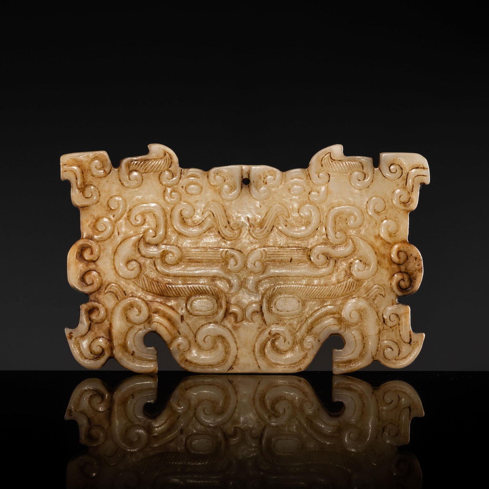 A YELLOW-BEIGE JADE 'TAOTIE' MASK, EASTERN ZHOU DYNASTY: A YELLOW-BEIGE JADE 'TAOTIE' MASK, EASTERN ZHOU DYNASTY China, 770-256 BC. Finely carved to one side in relief with a taotie mask flanked by a pair of confronted dragon heads above, well detailed with