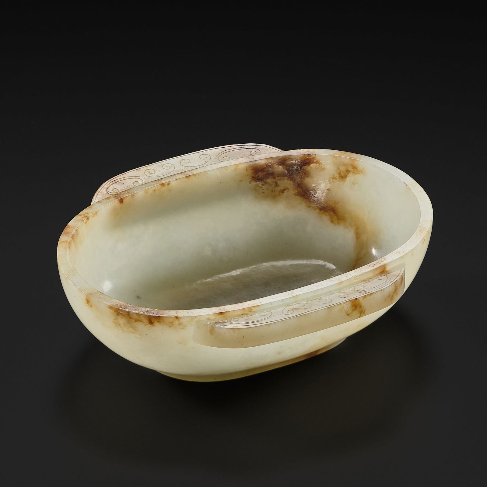 A PALE GREEN AND RUSSET JADE EAR CUP, HAN DYNASTY (1 of 16)